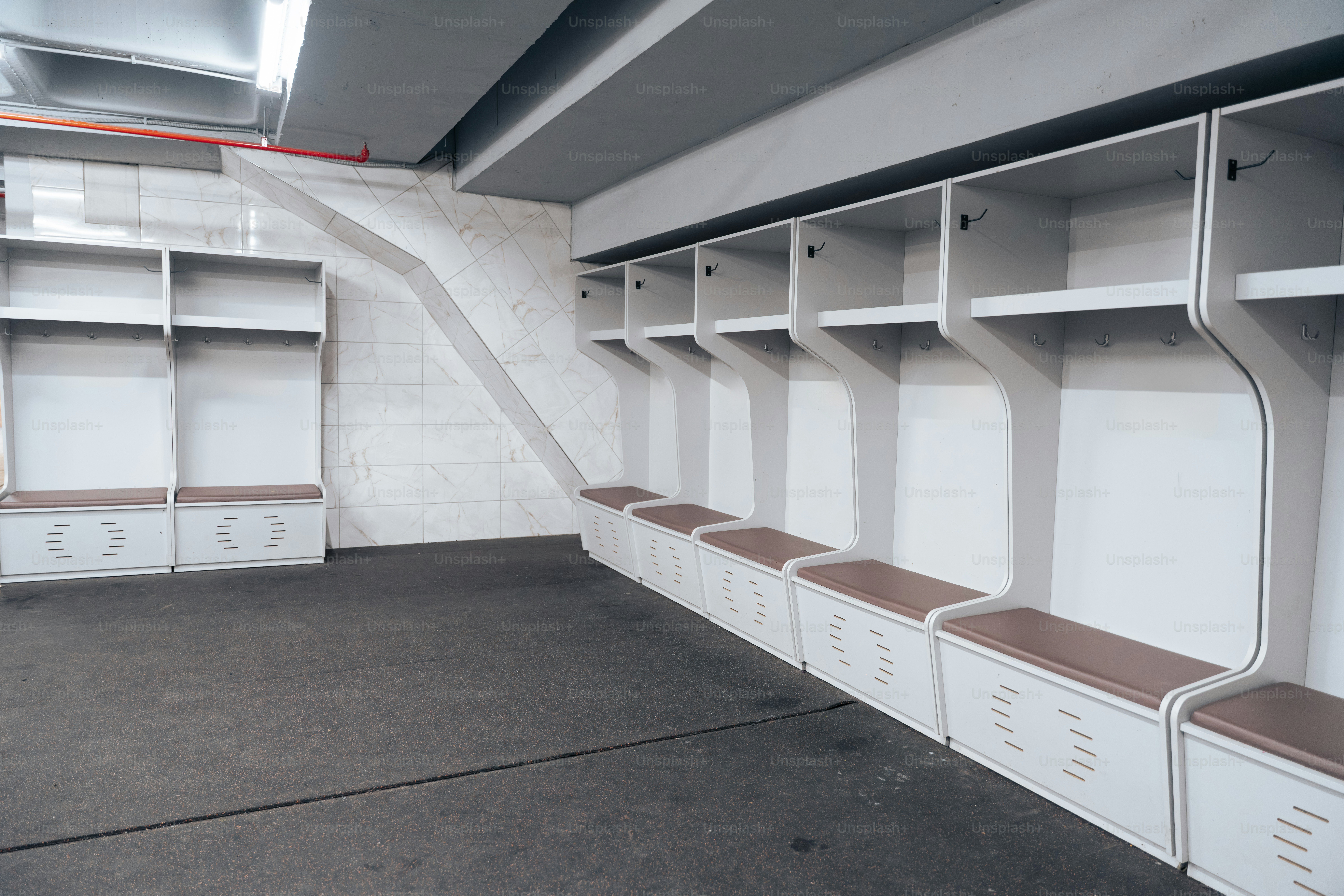 Casiers blancs vides et bancs dans un vestiaire