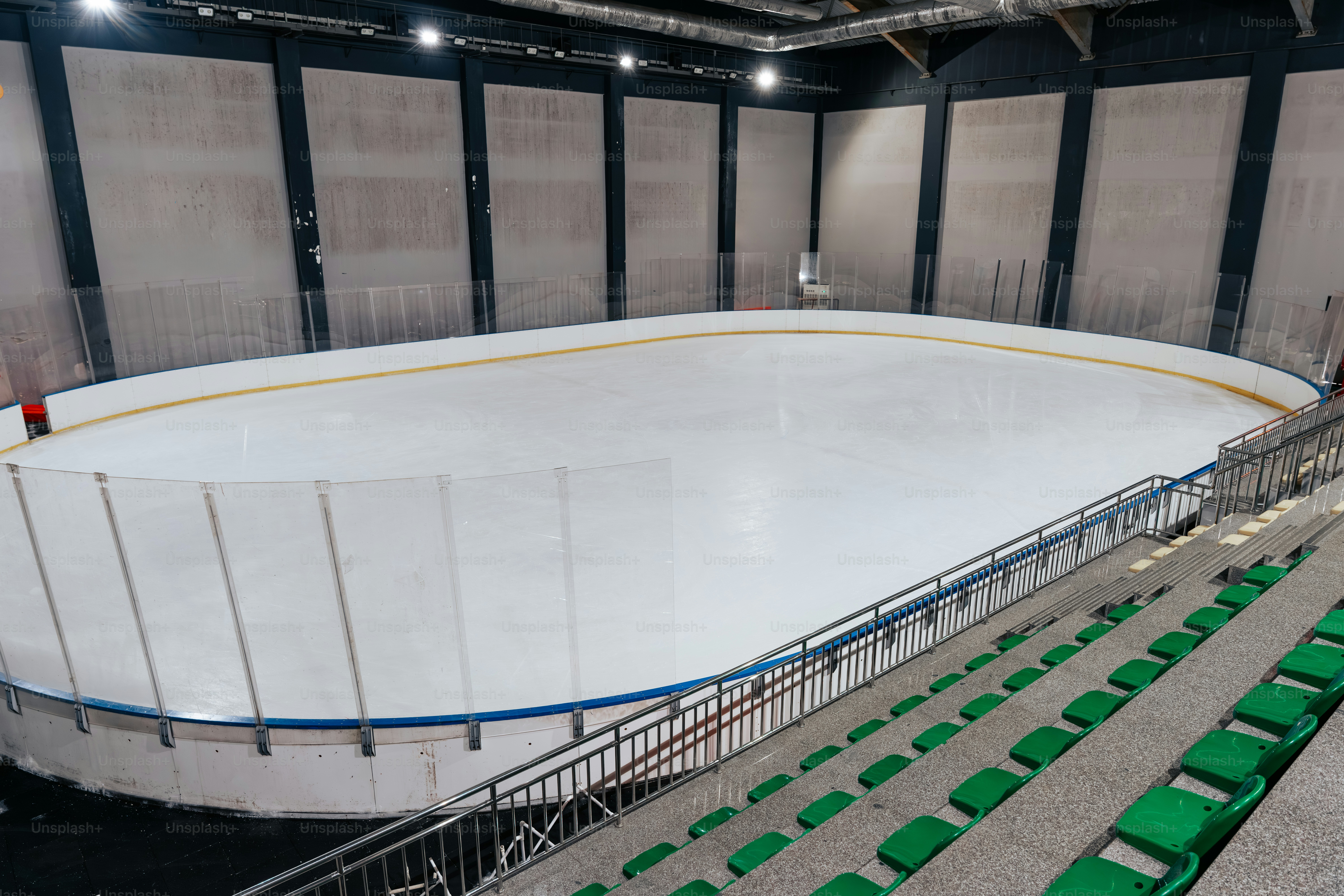 빈 실내 아이스 스케이팅장과 녹색 좌석