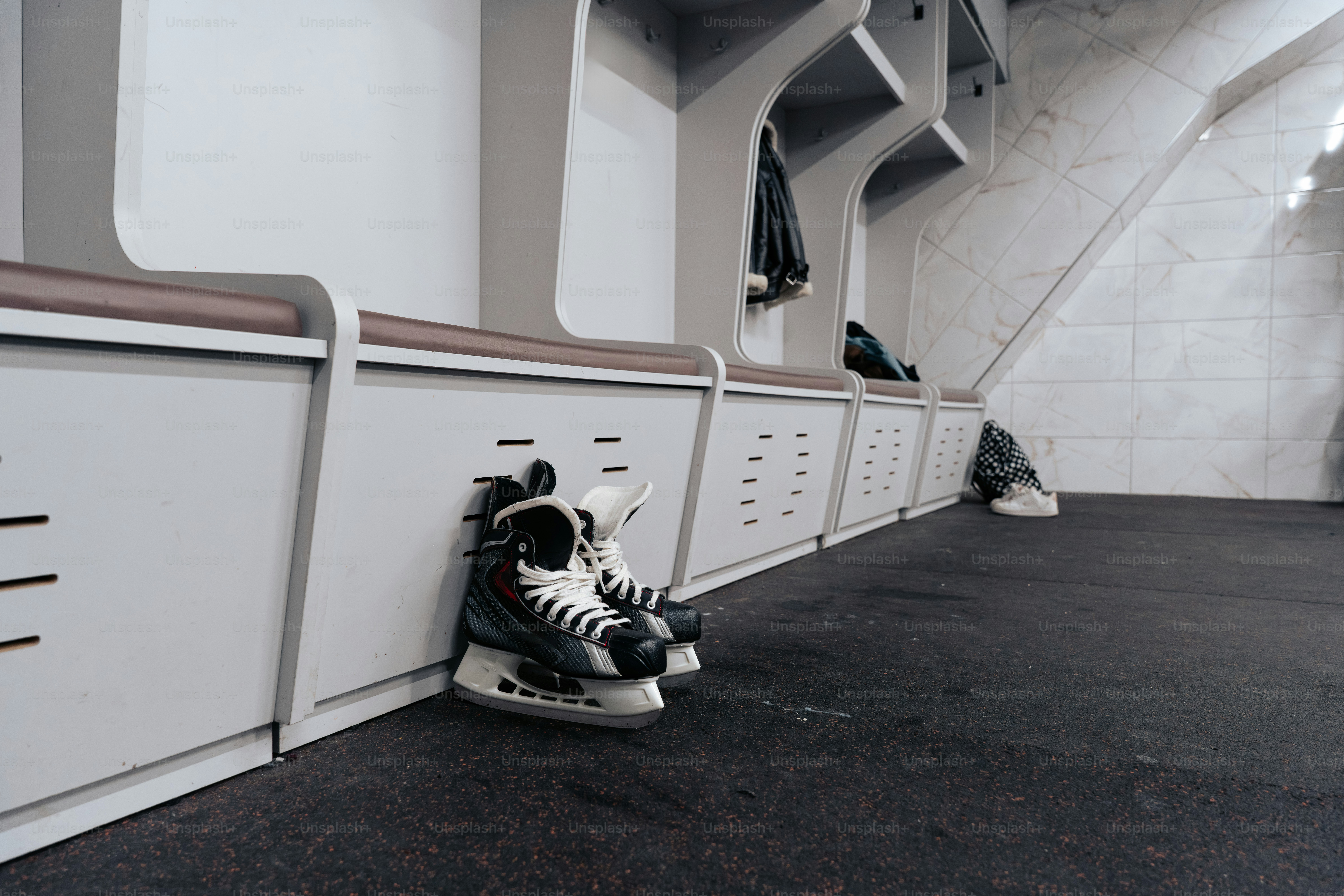 라커룸에서 아이스하키 스케이트를 타고 있다.