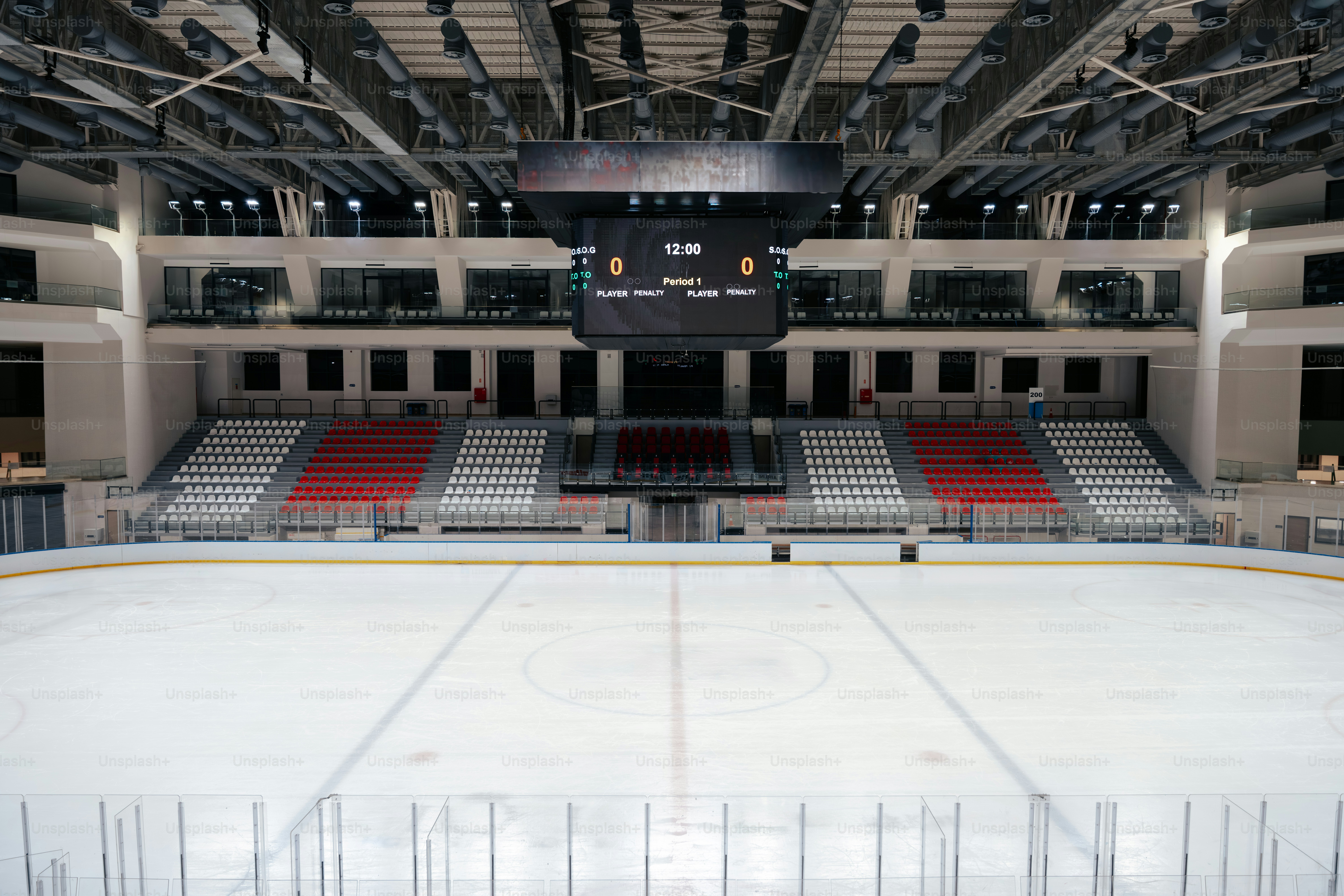 Empty ice hockey arena with seating and scoreboard