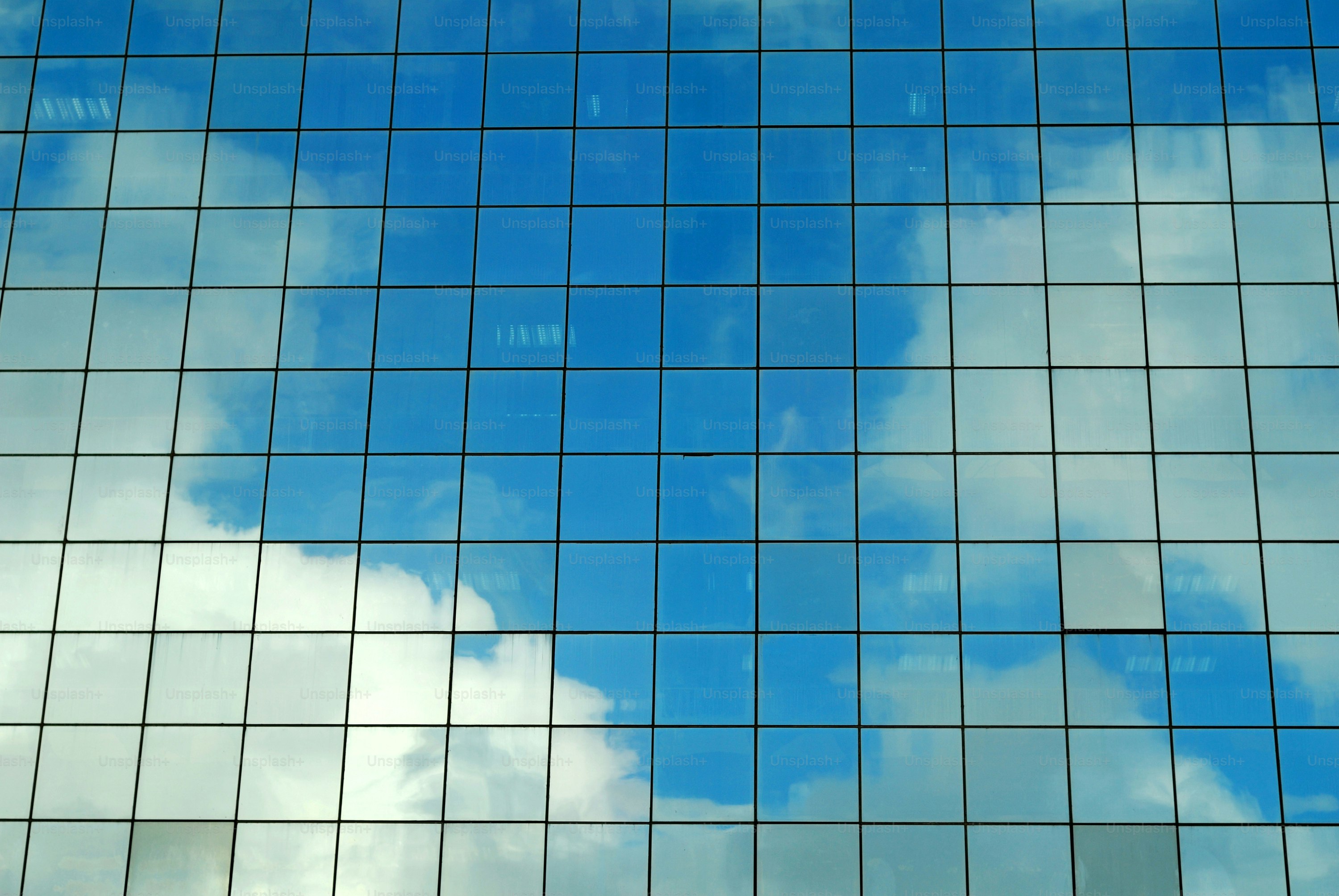 Sommerhimmel spiegelt sich in einem modernen Bürogebäude.