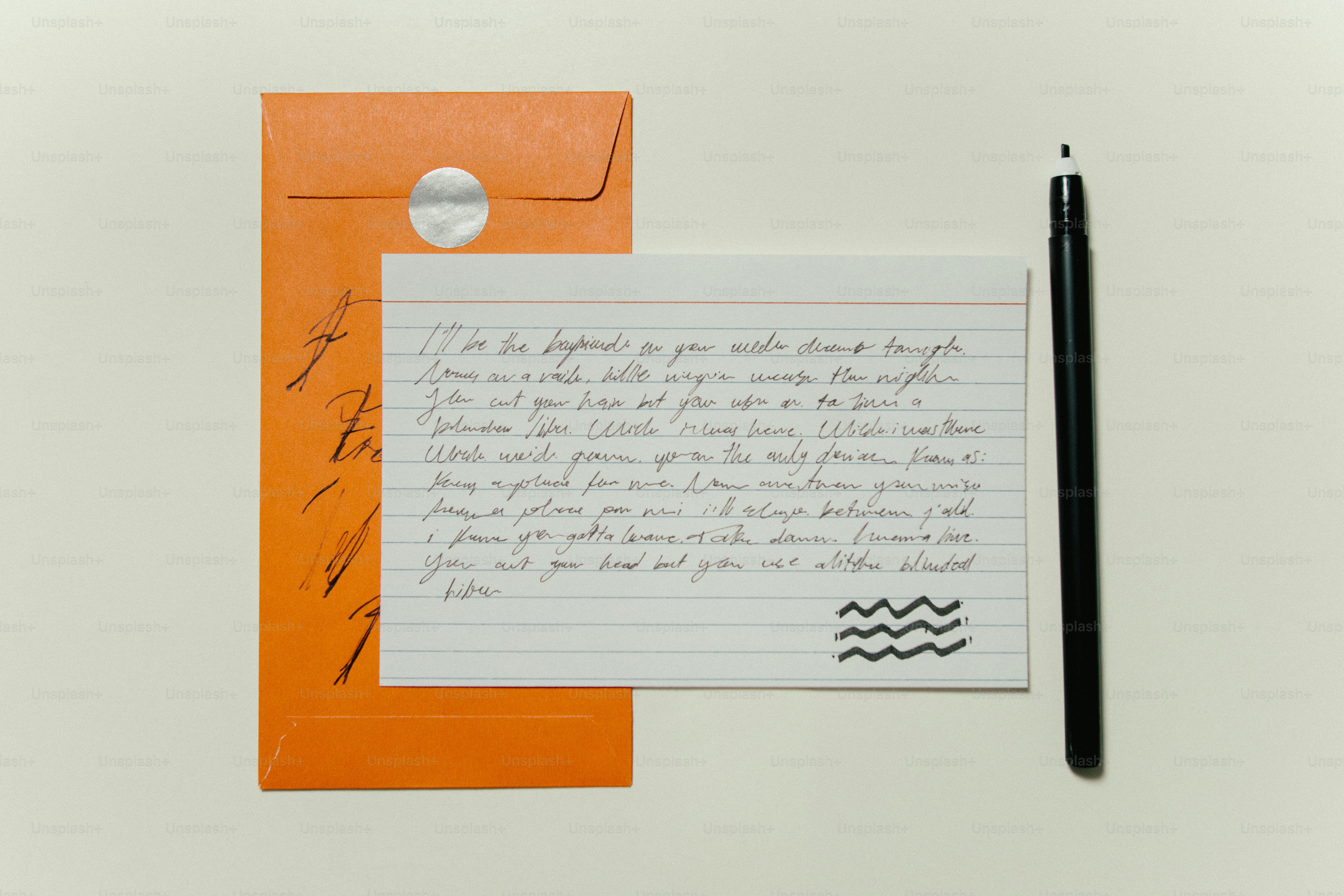 A handwritten note with an orange envelope and pen.
