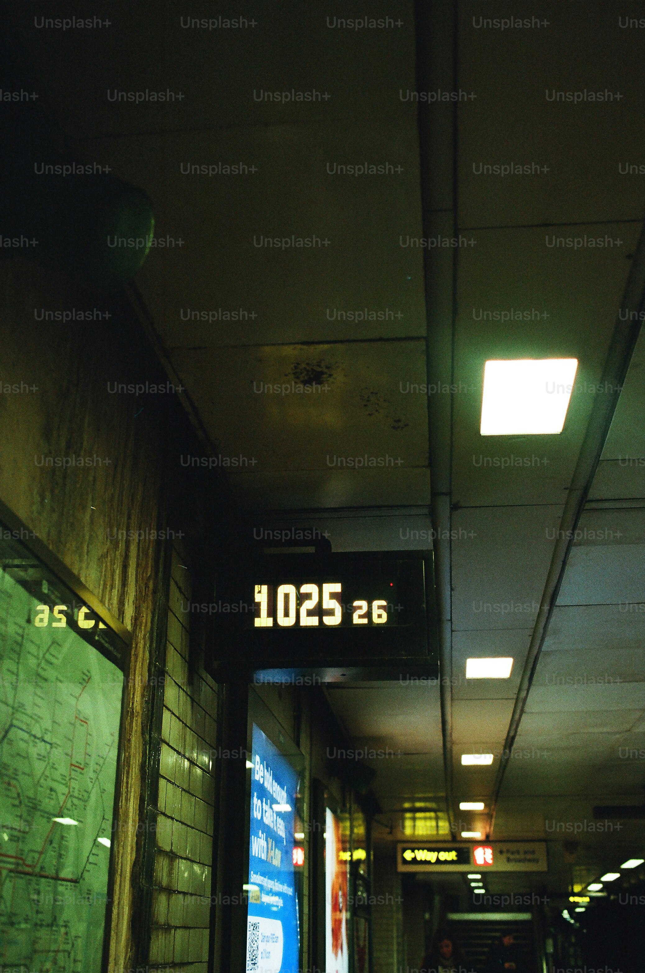 Digital clock displays 10:25 in a subway station.