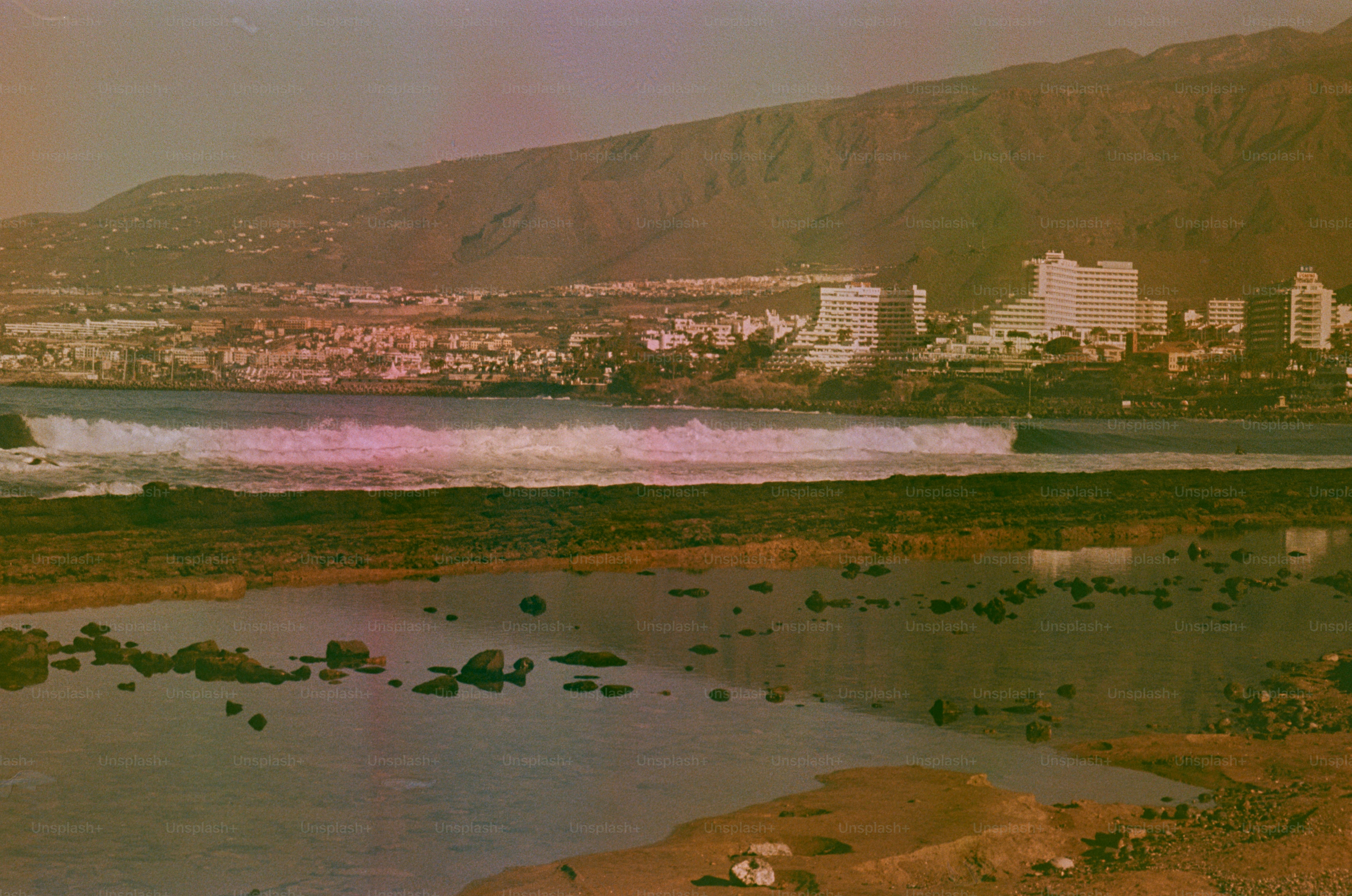 Coastal city with ocean waves and mountains