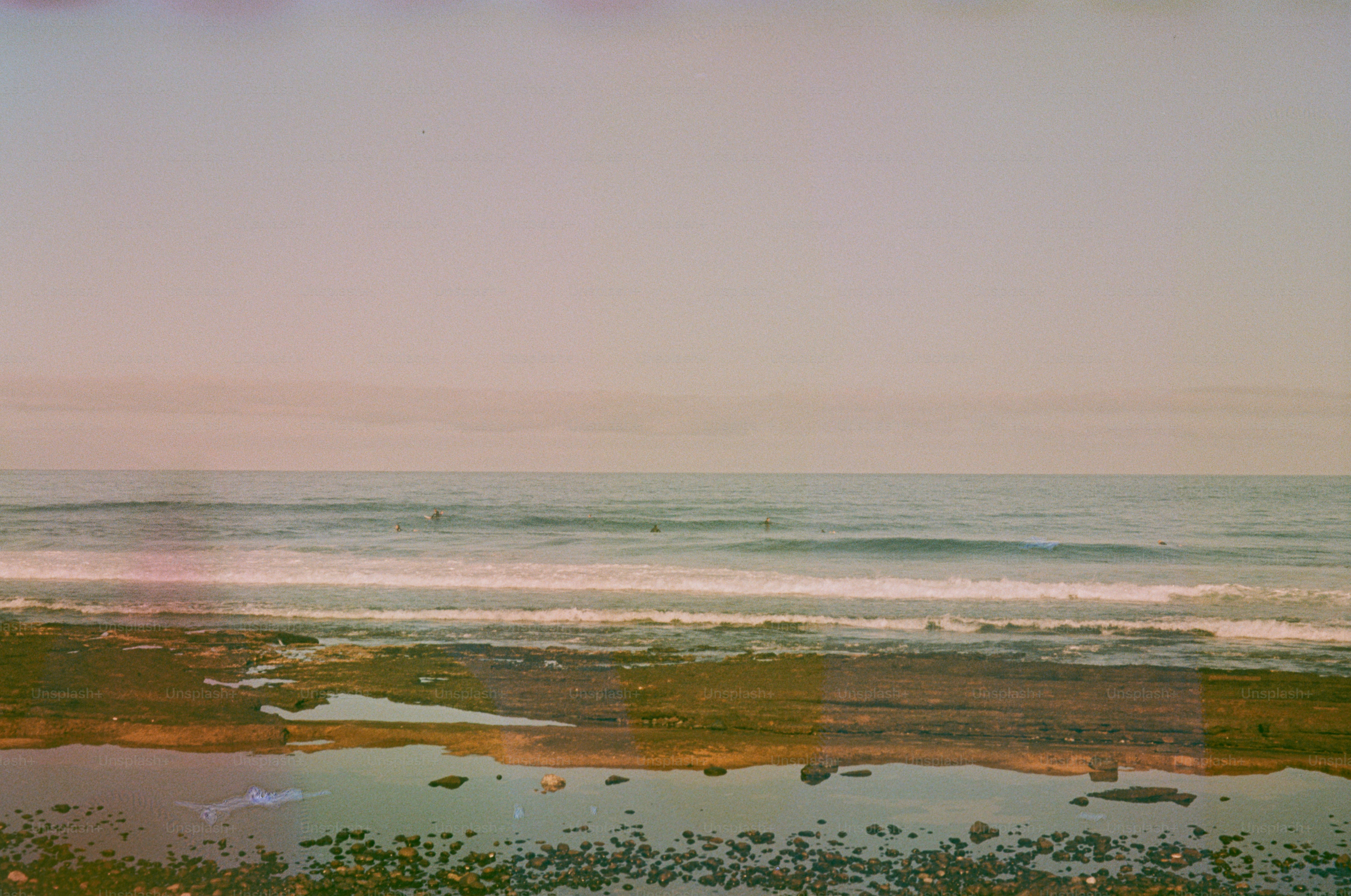 Ocean waves gently roll onto a rocky shore.