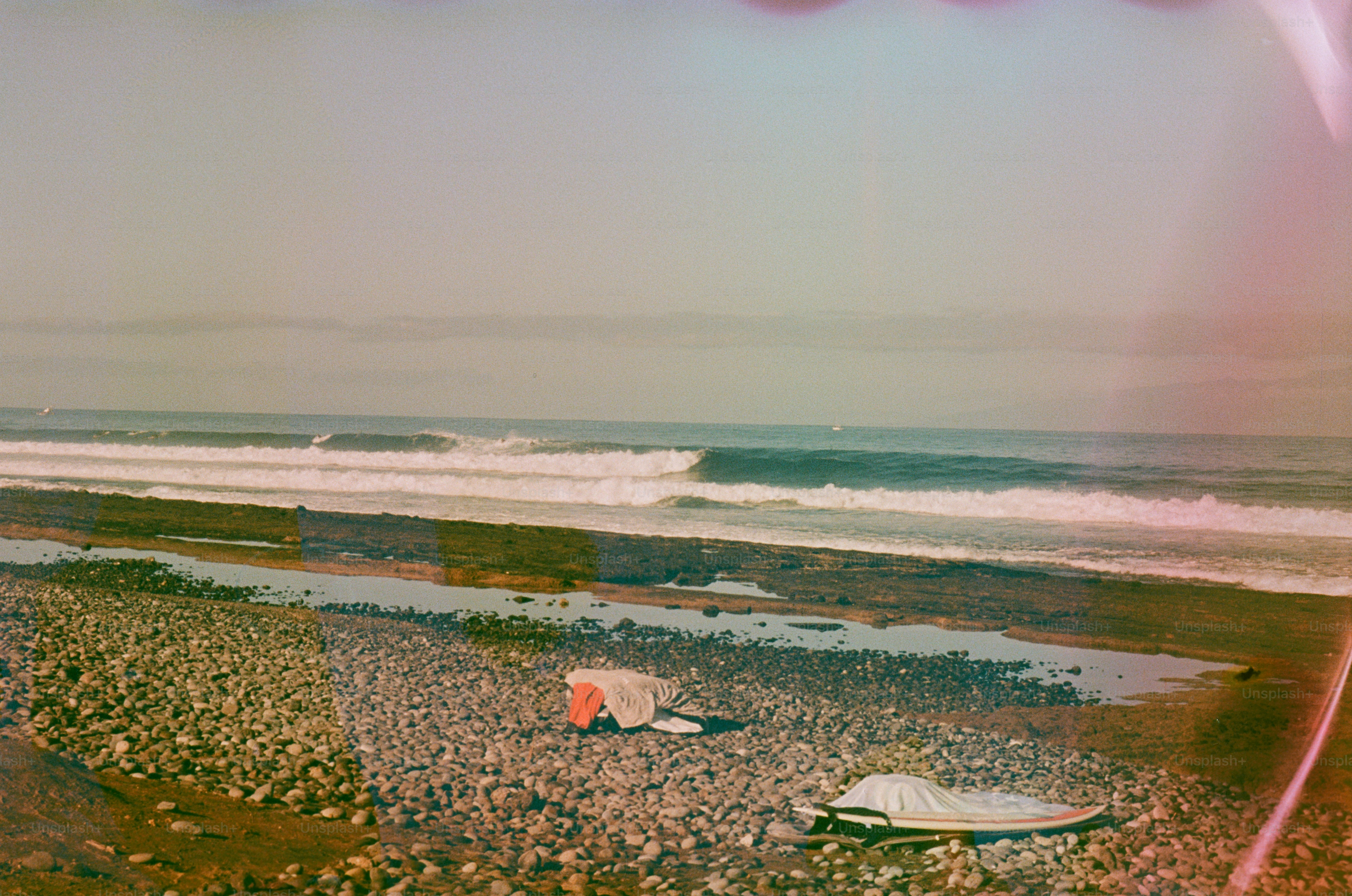 Waves breaking on a rocky shore with beach gear