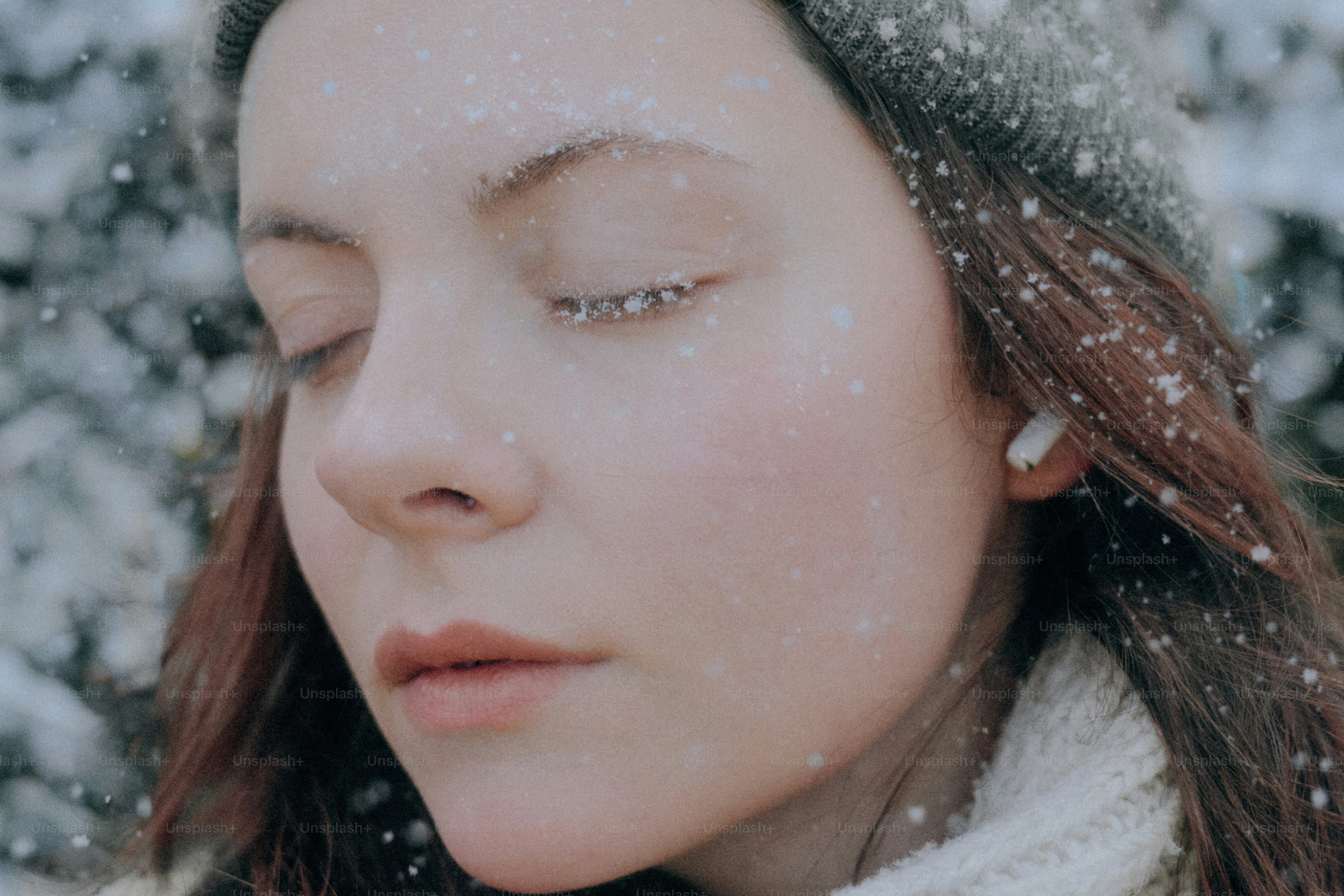 A young woman with snow on her face in winter.