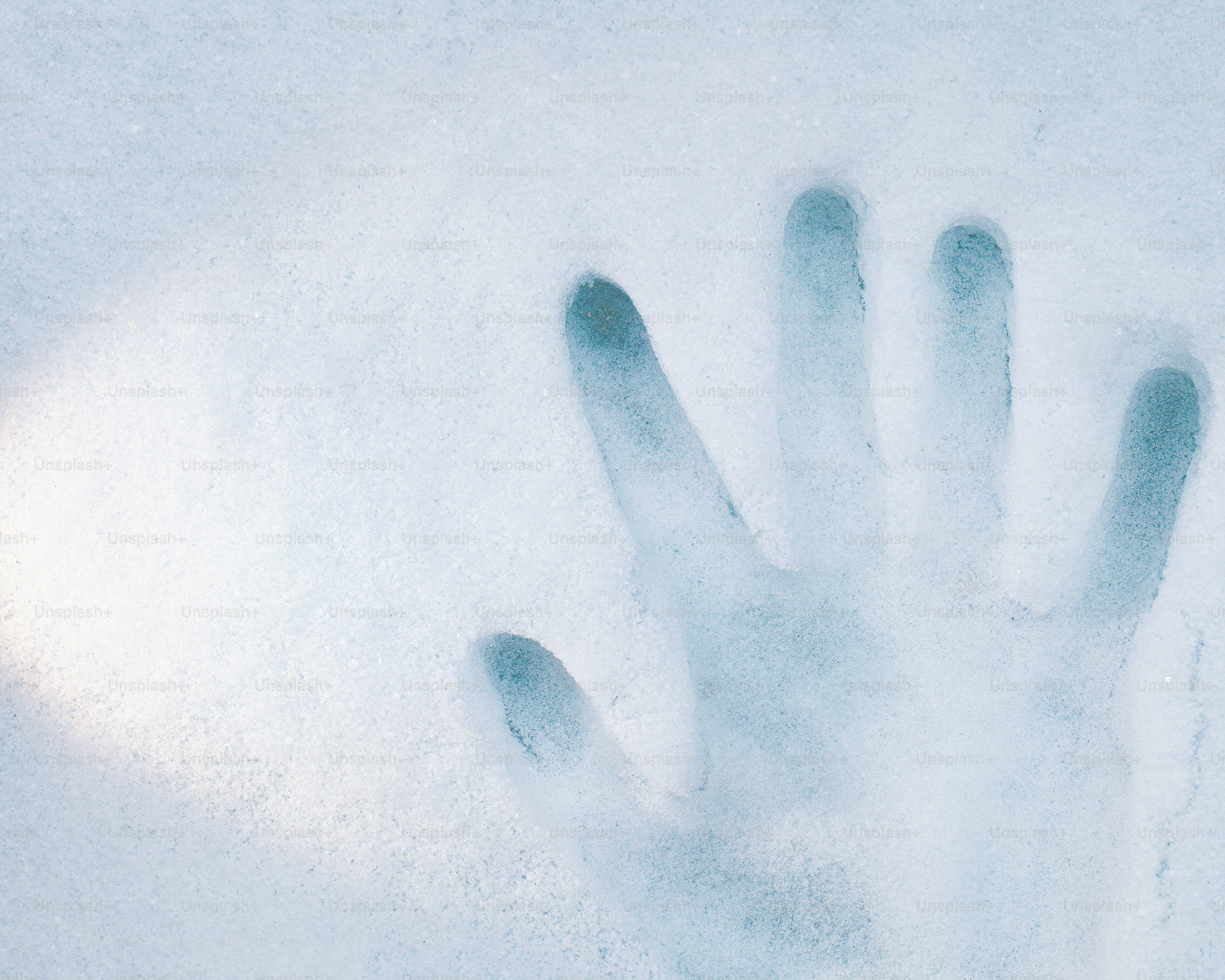 Handprint pressed into icy surface