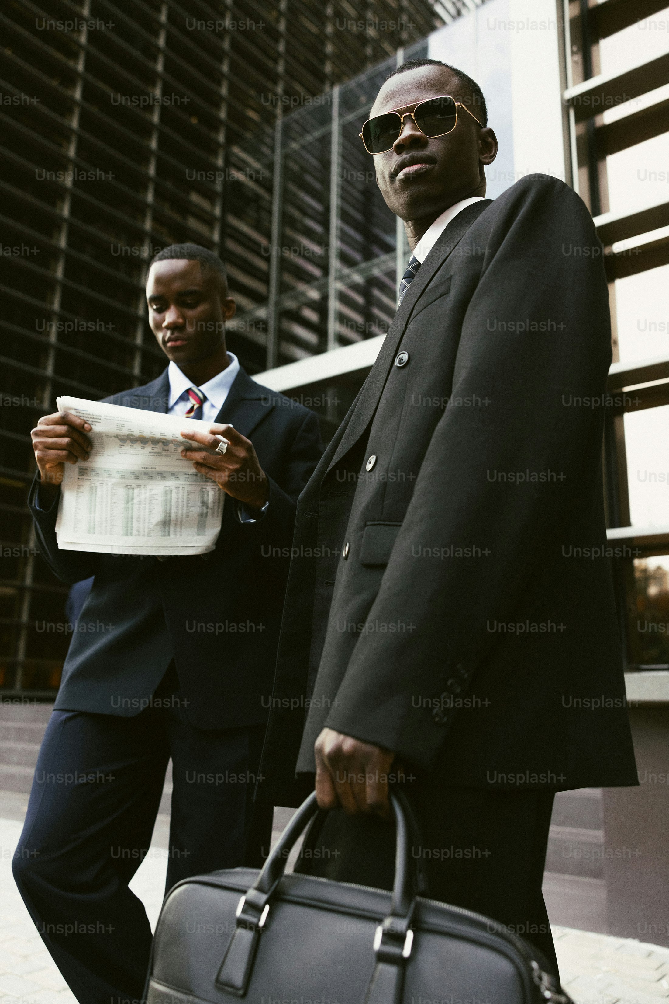 Two businessmen in suits outside a modern building