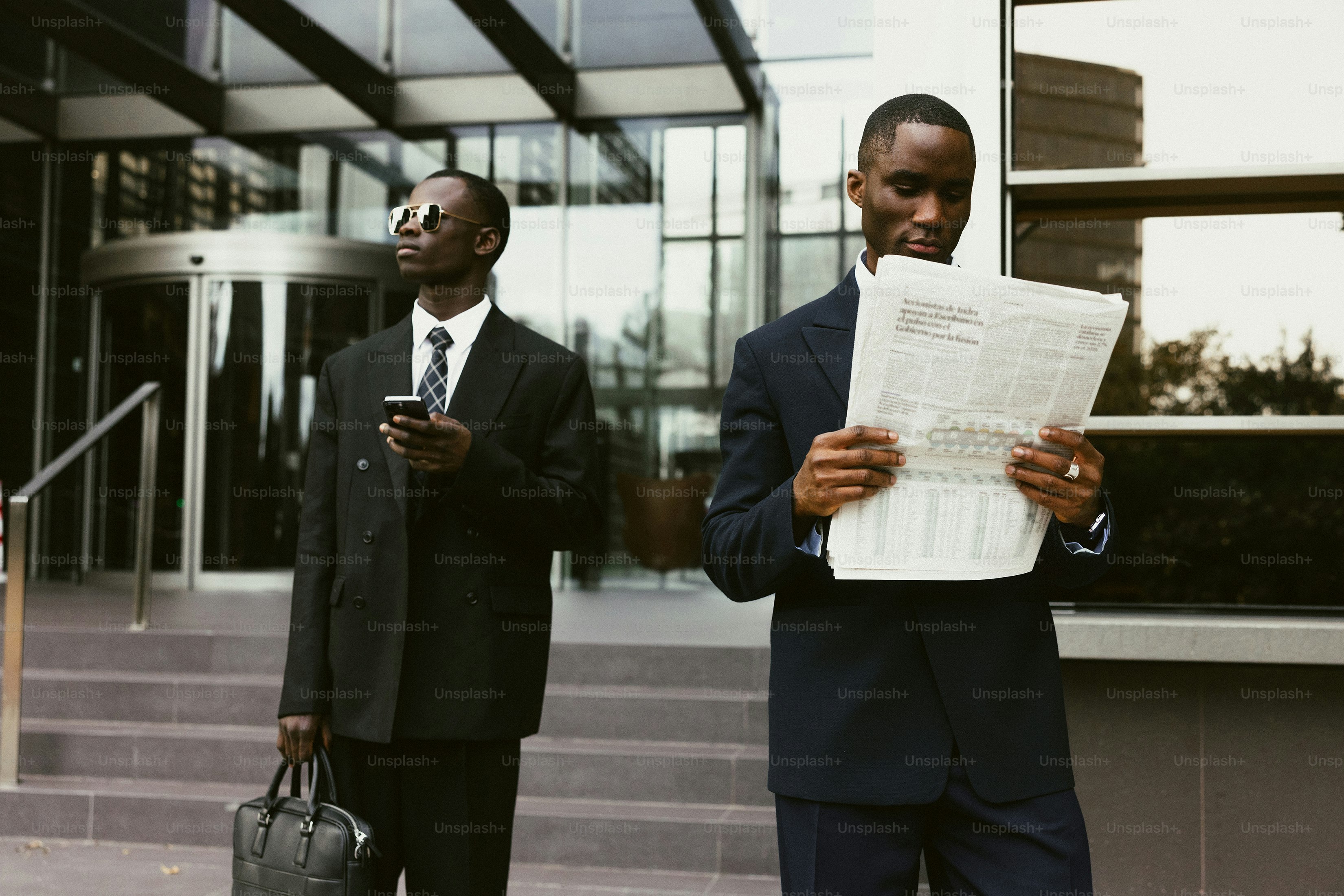 Two businessmen in suits outside modern building