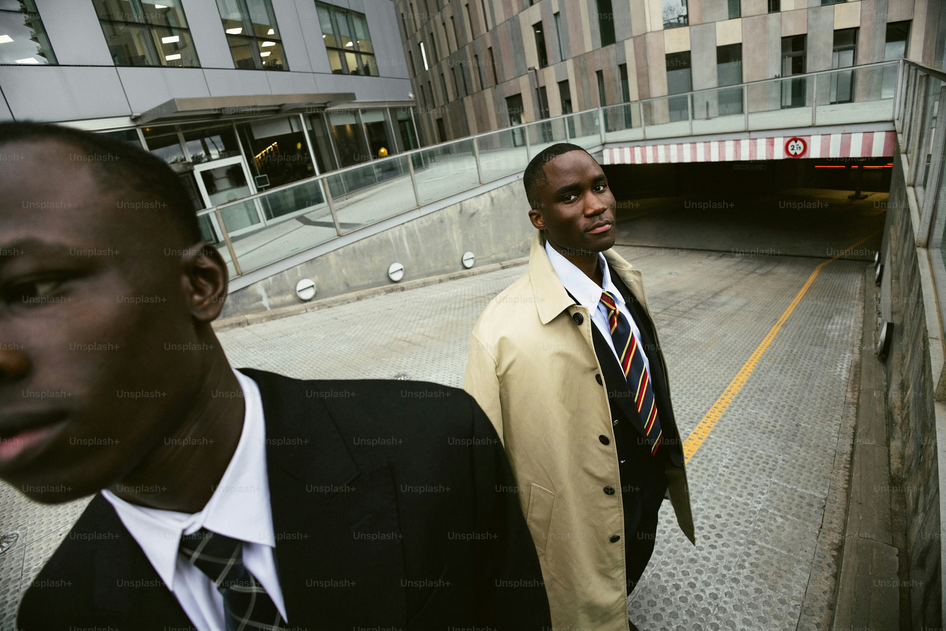 Two businessmen stand in an urban environment.