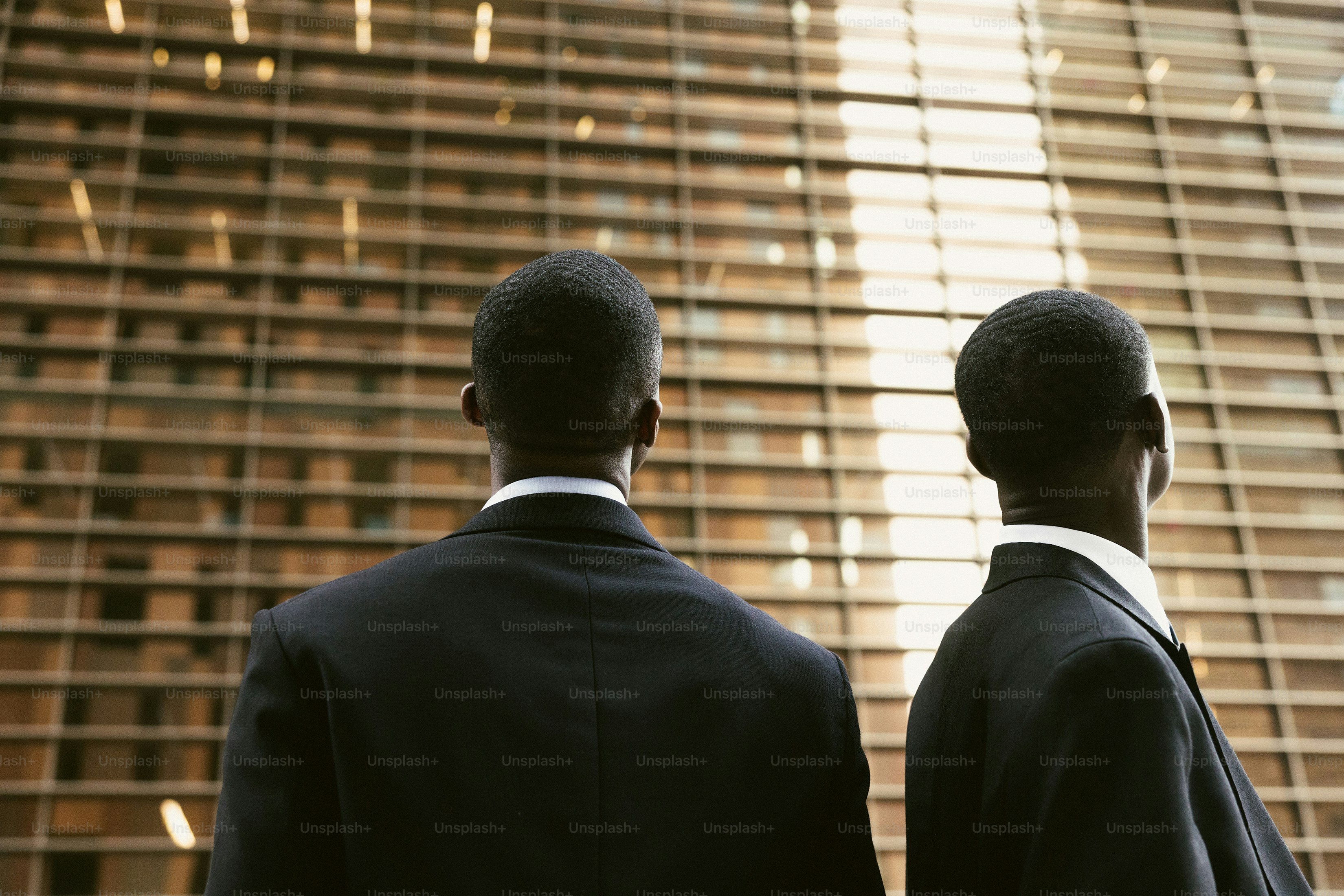 Two men in suits looking at a building