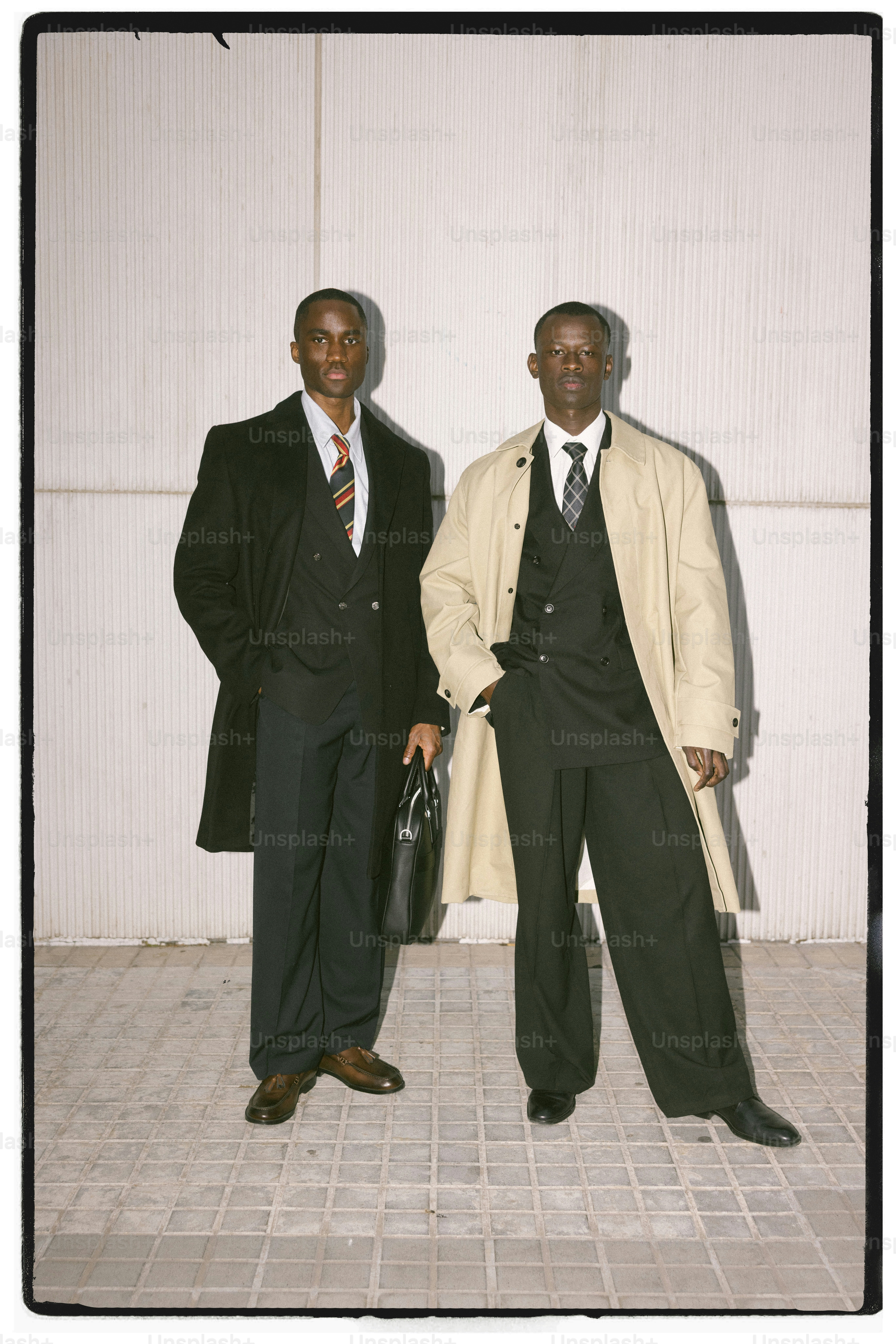 Dois homens de terno estão lado a lado.