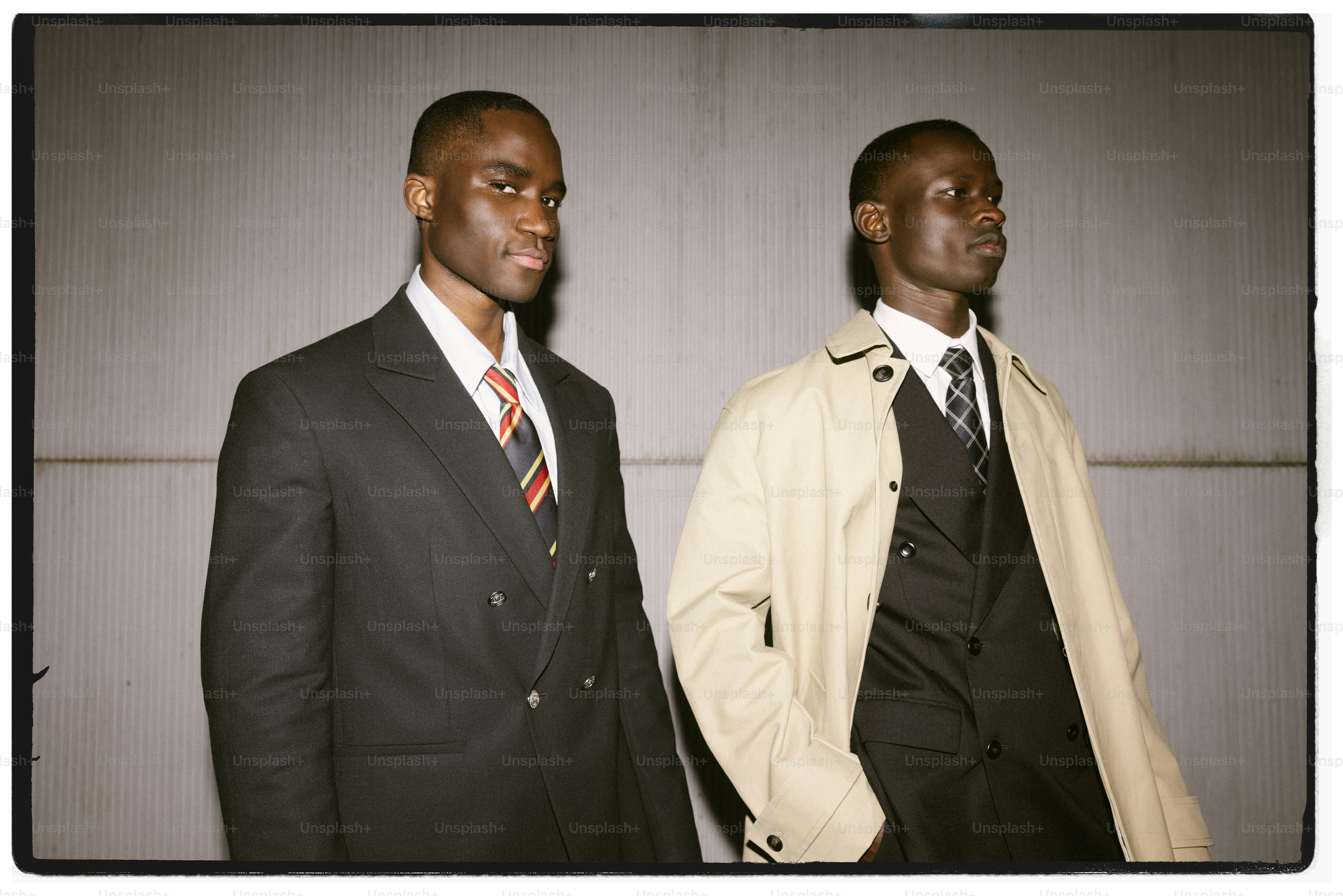 Two men in suits walking together outdoors.