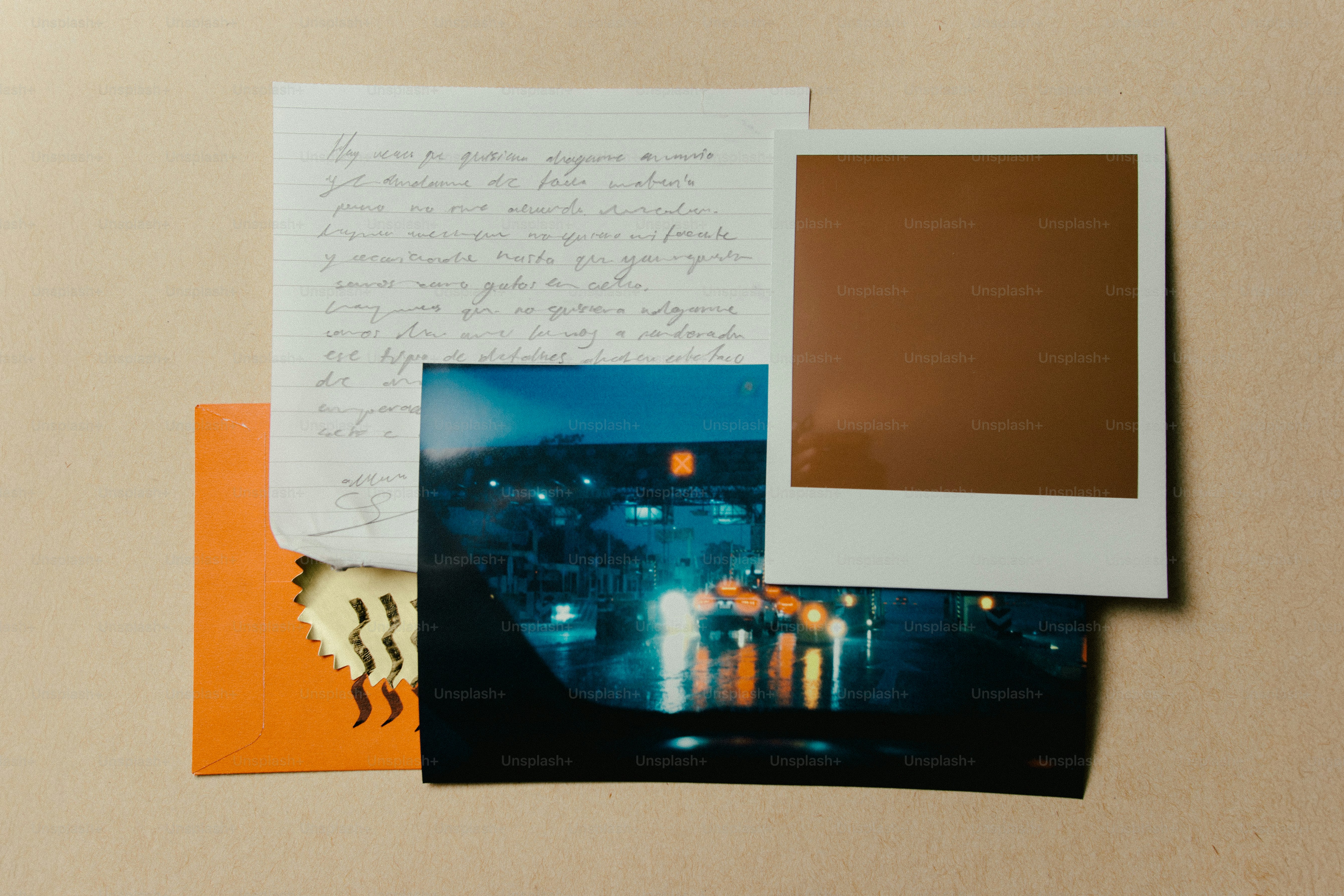 Polaroid, huruf, dan foto dengan latar belakang krem