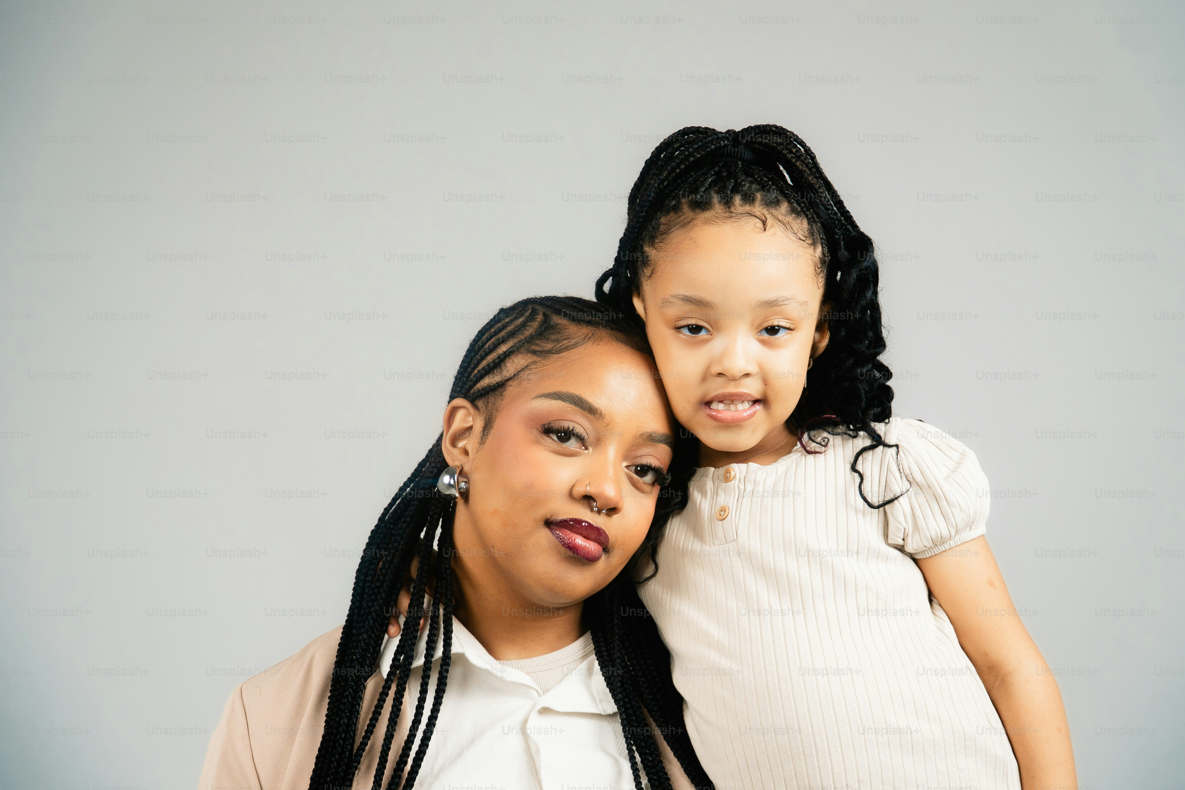 Mutter und Tochter posieren zusammen mit Zöpfen