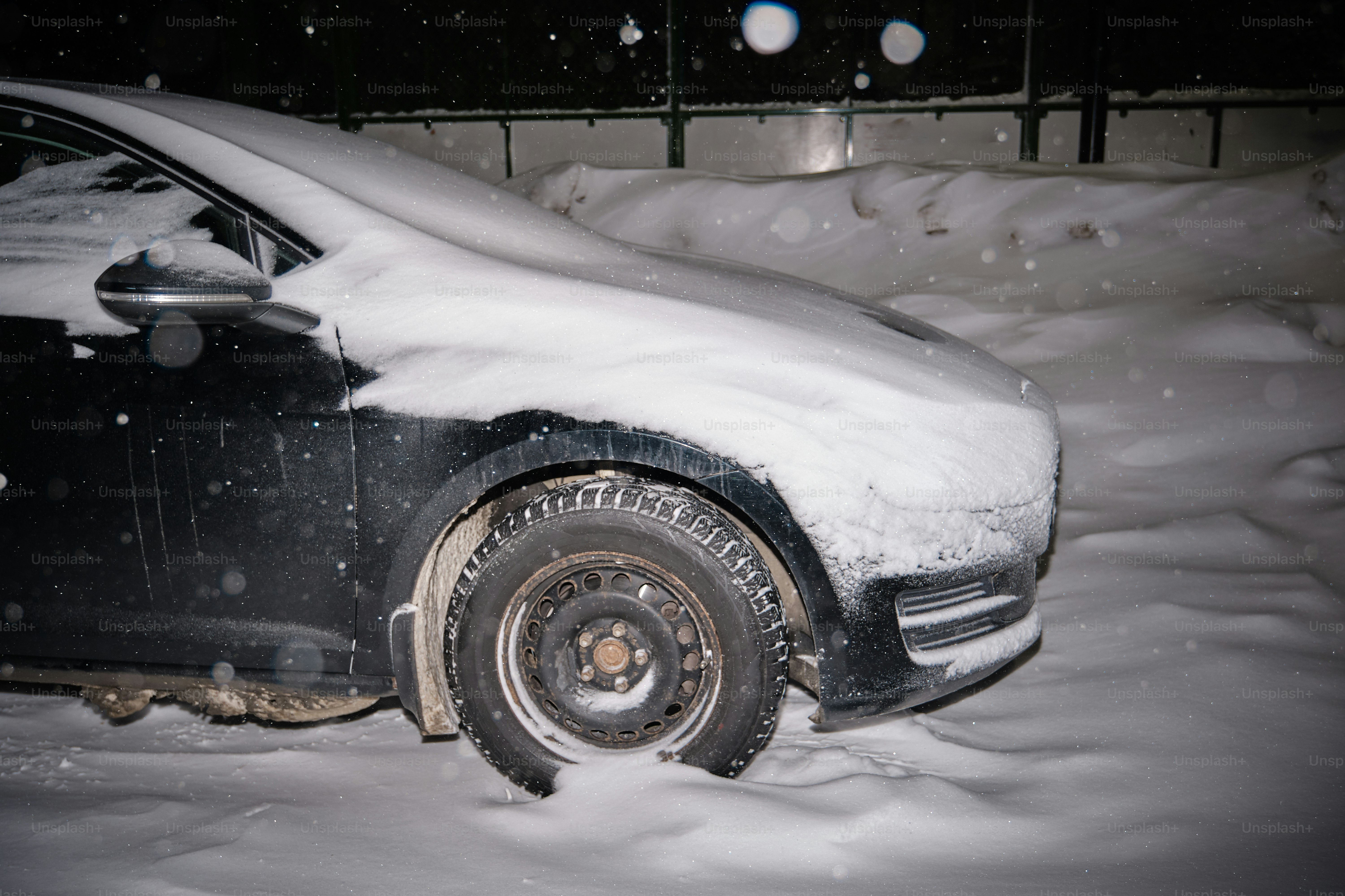 Um carro coberto de neve durante uma queda de neve