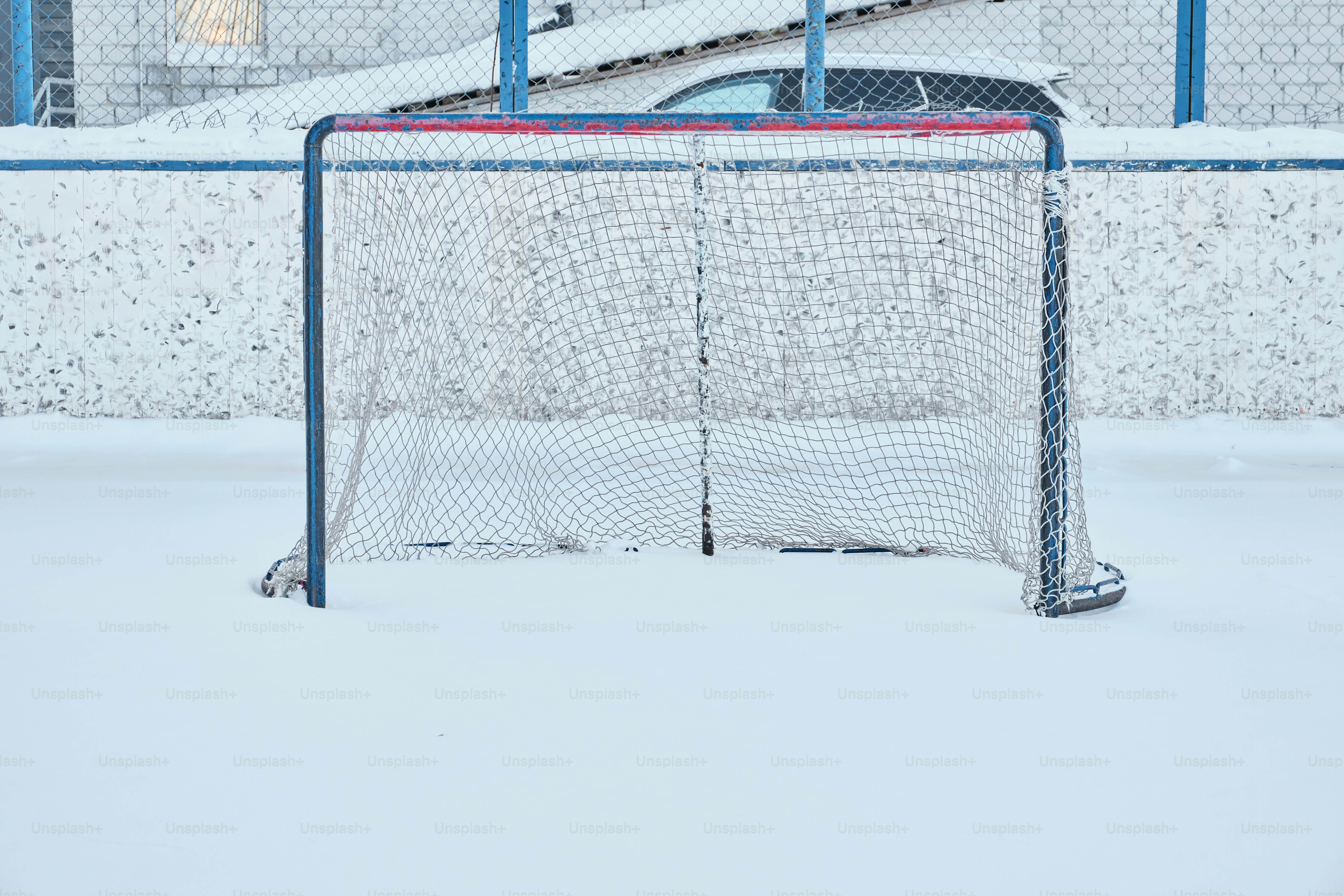 A hockey goal net sits on a snow-covered ice rink. photo – Winter Image ...