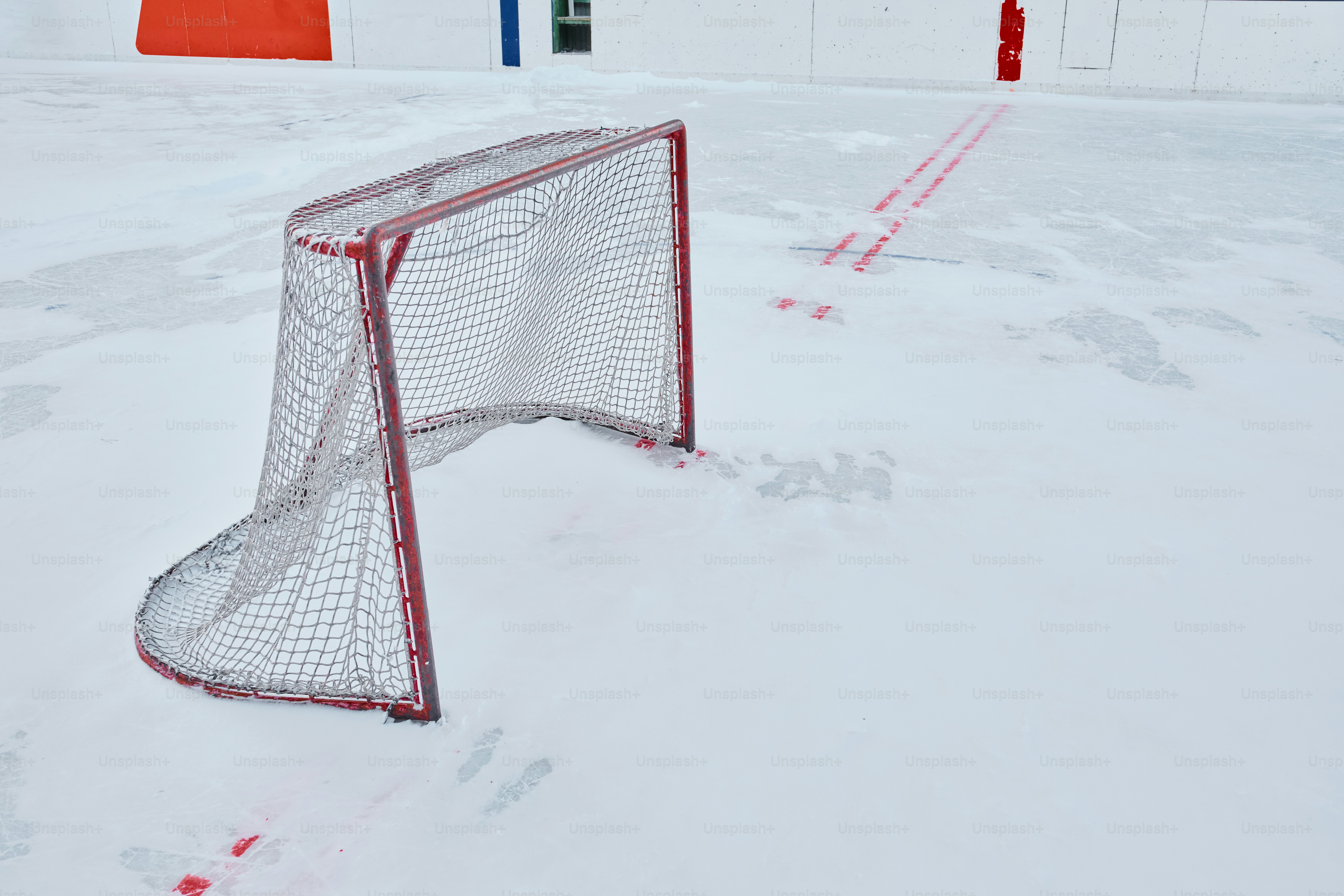 Snow covered hockey rink with goalposts in distance photo – Hockey ...