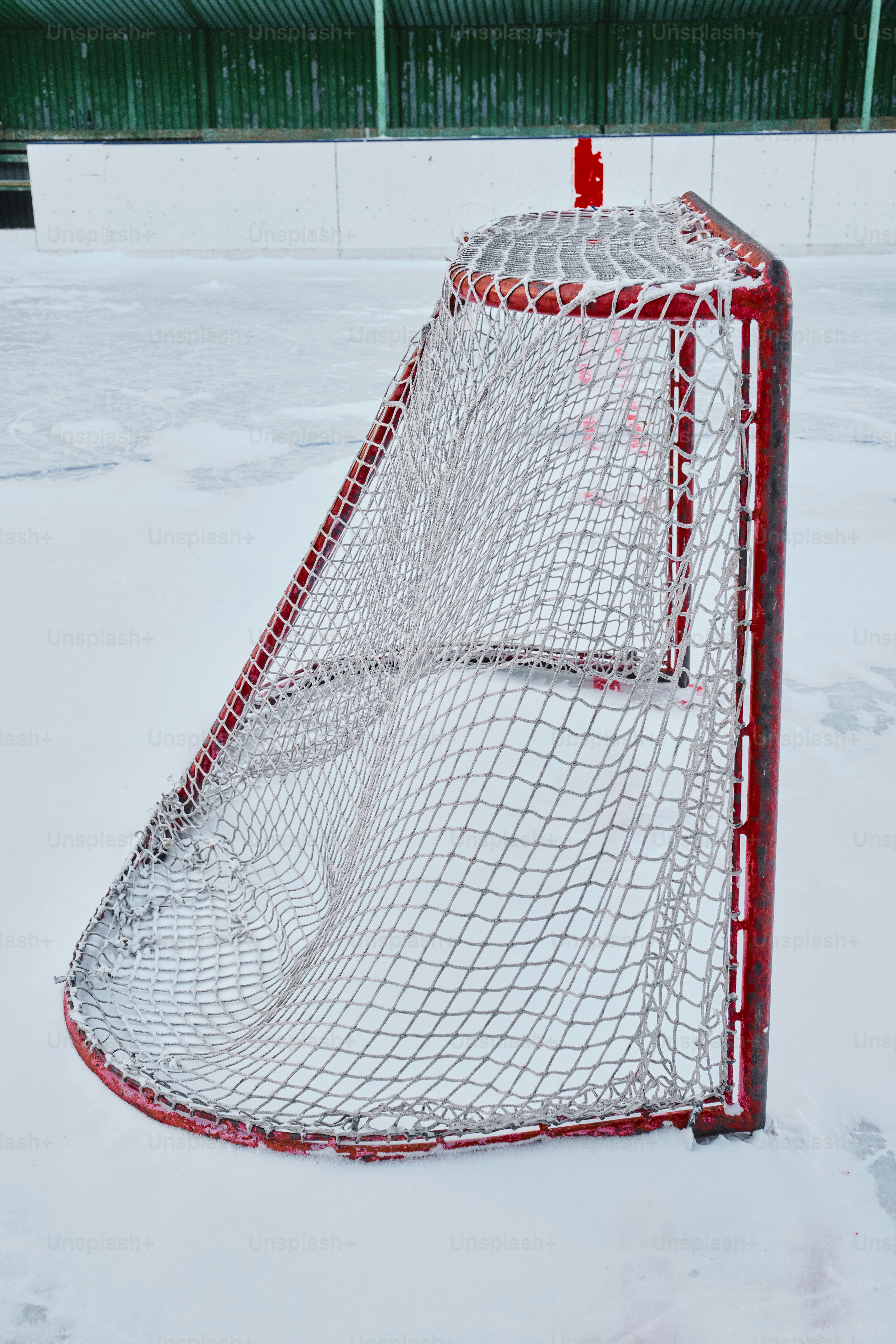 A hockey goal net sits on a snow-covered ice rink. photo – Winter Image ...
