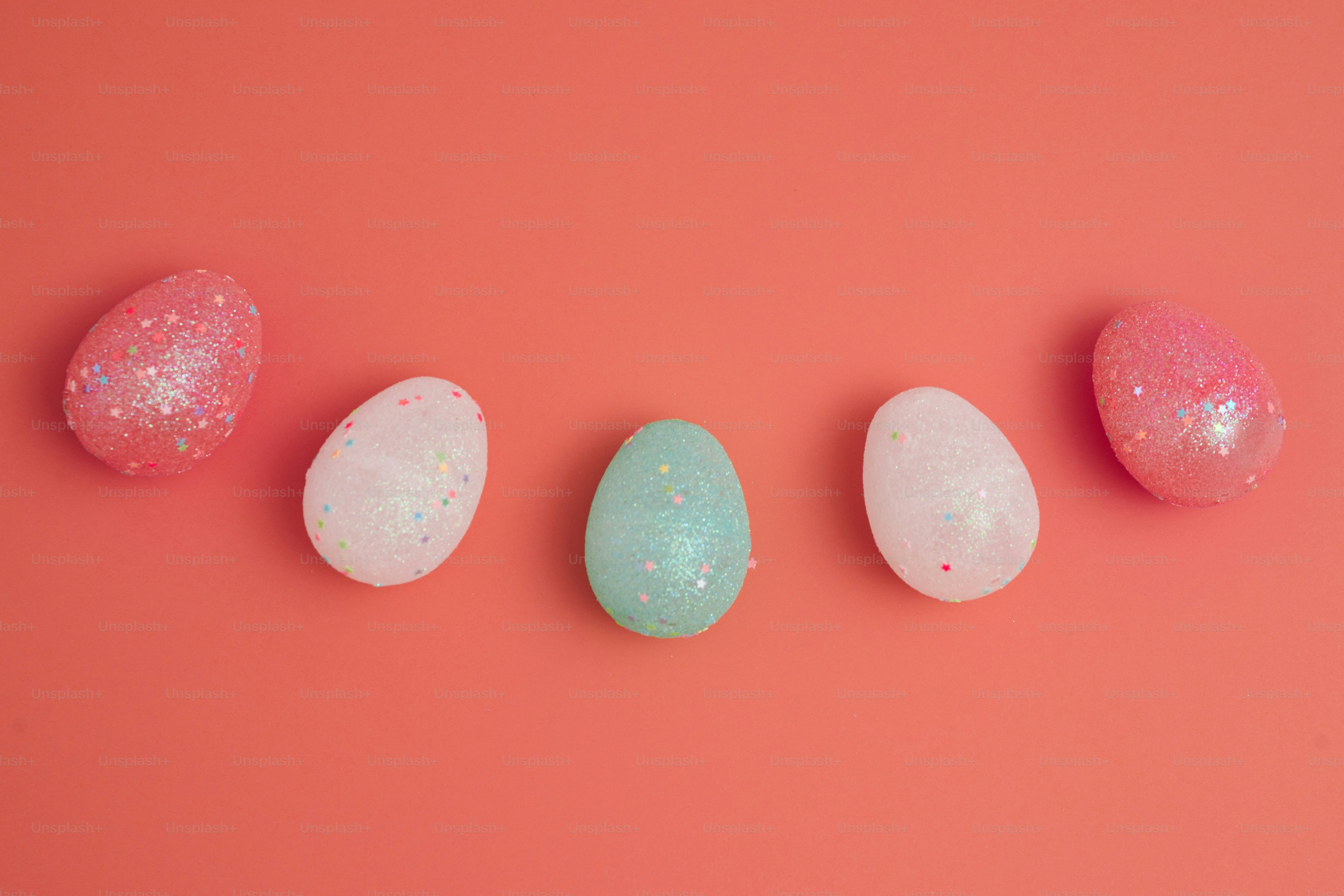 Lima telur paskah pastel dengan glitter di latar belakang karang