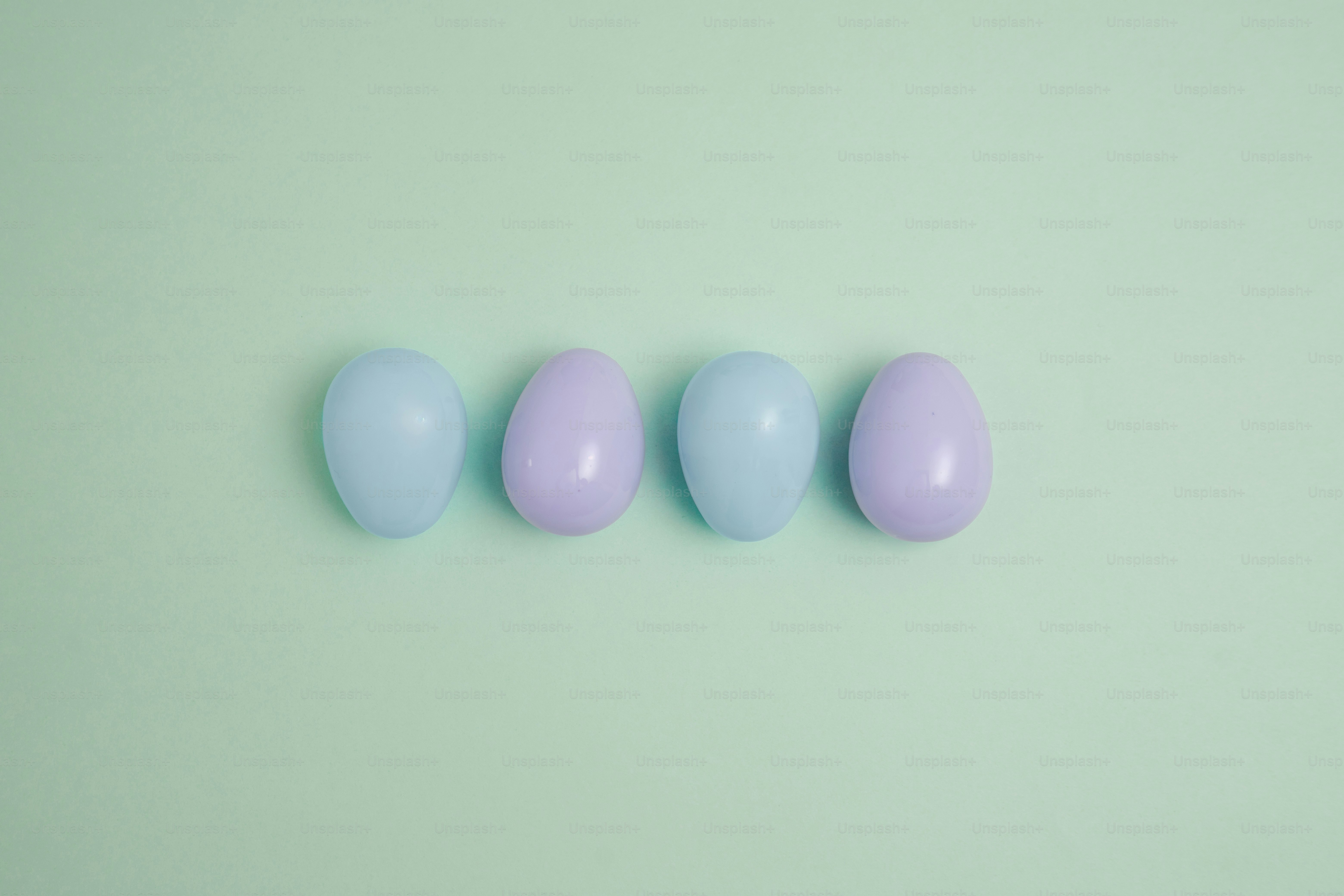Empat telur paskah pastel dengan latar belakang hijau mint