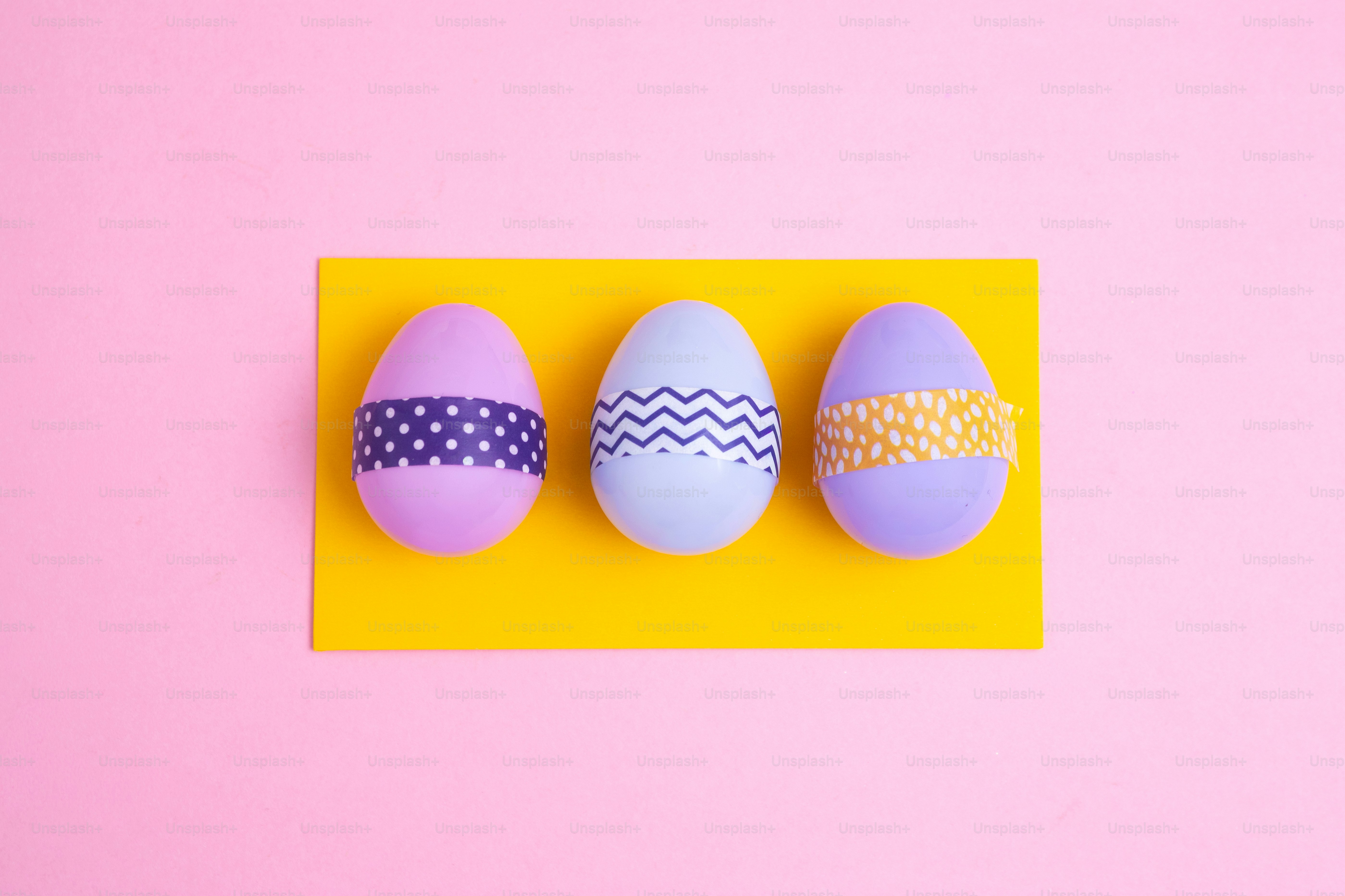 Tiga telur paskah yang dihiasi dengan kartu kuning.