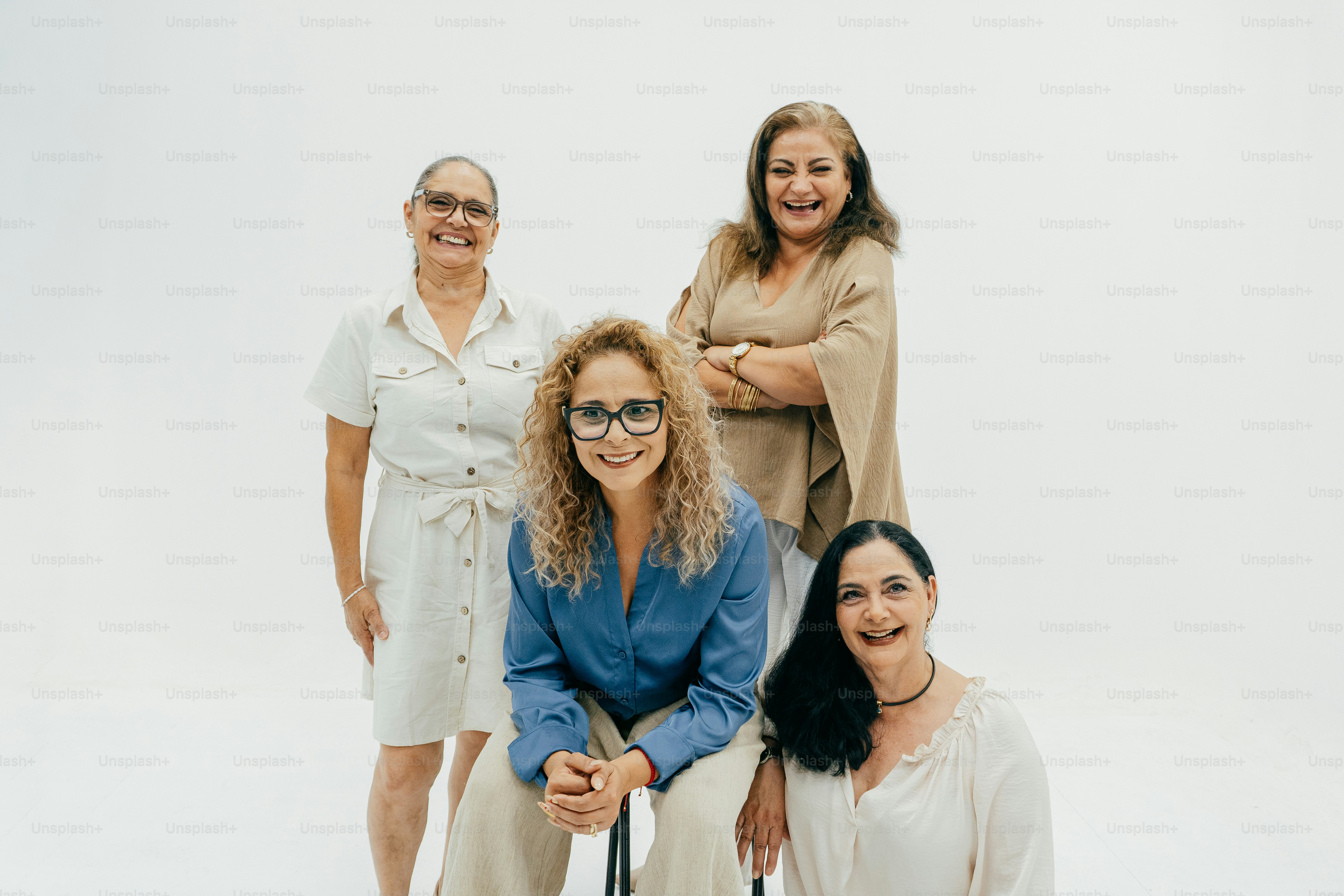 Four women posing together against a white background.