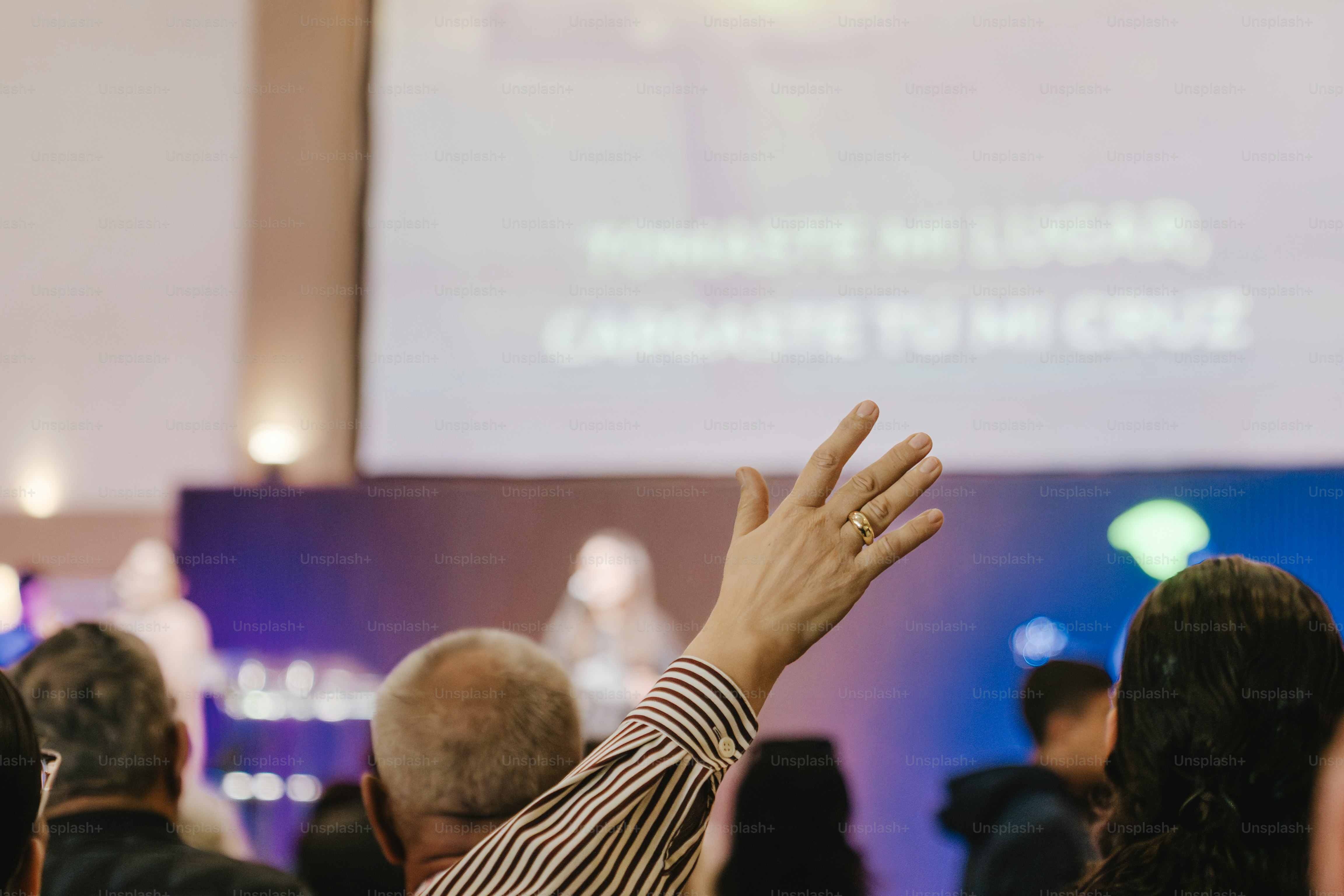 Una persona alza la mano durante un servizio di culto.