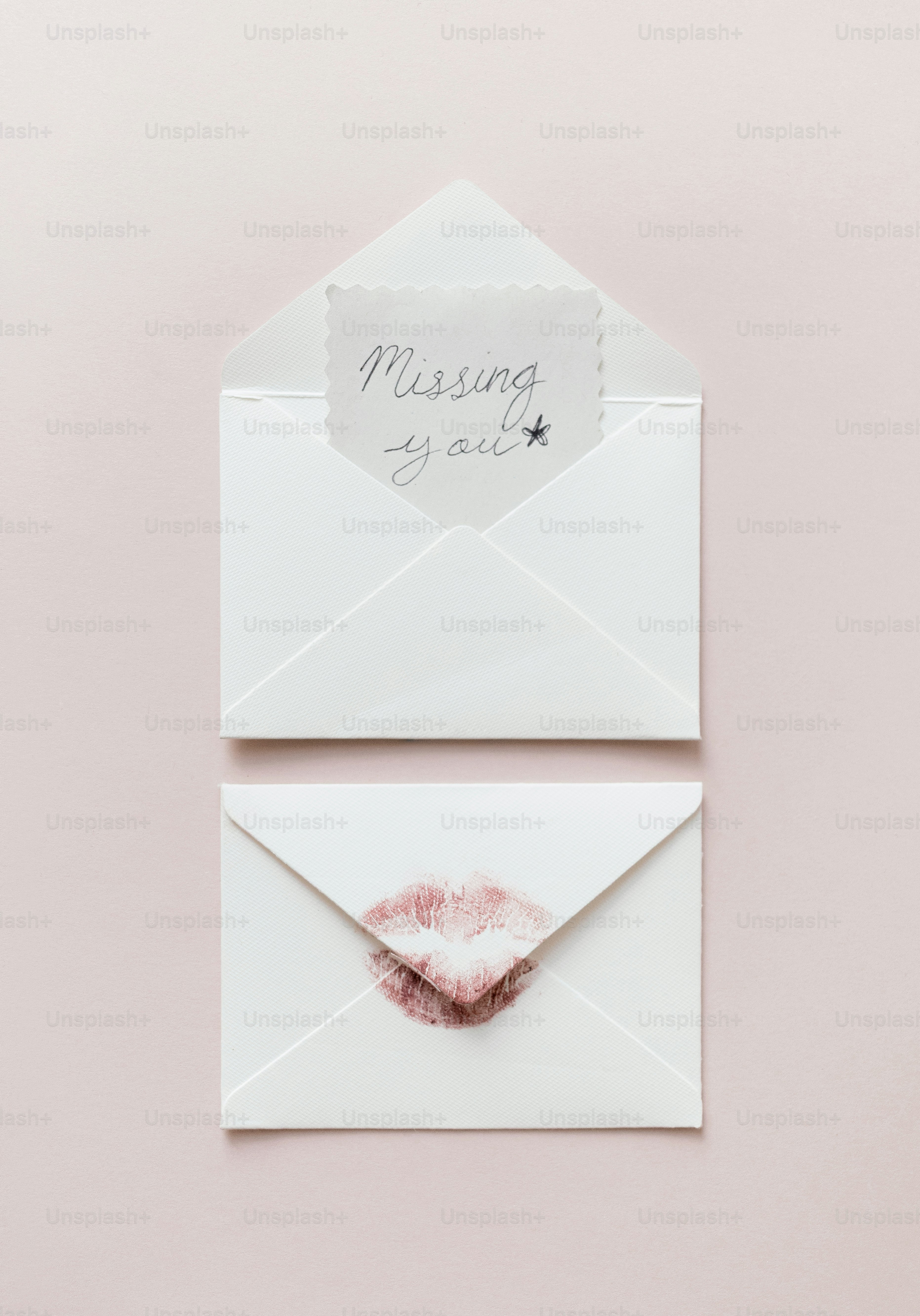 Two envelopes, one with a kiss mark, one with message.