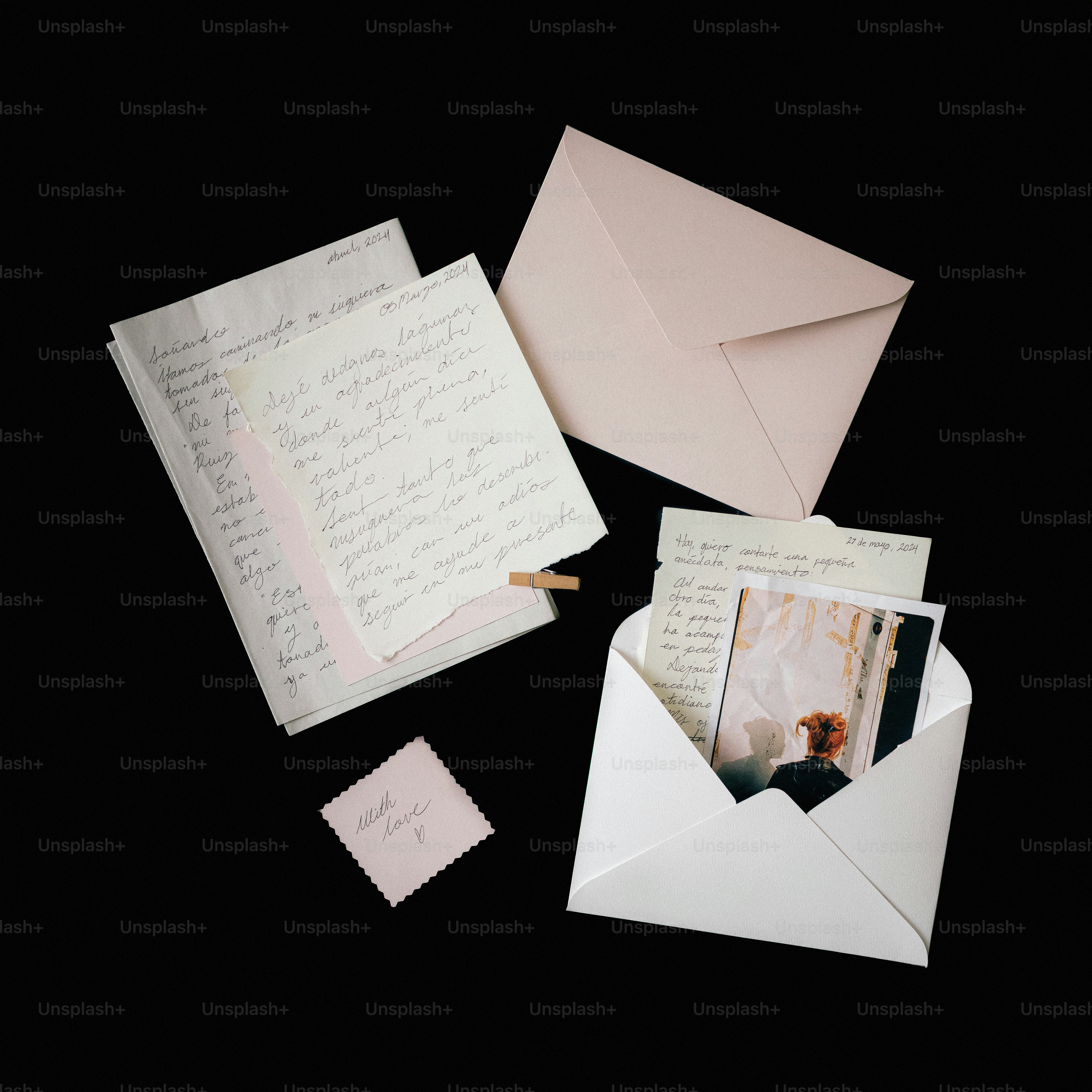 Letters and photographs scattered on a black background.
