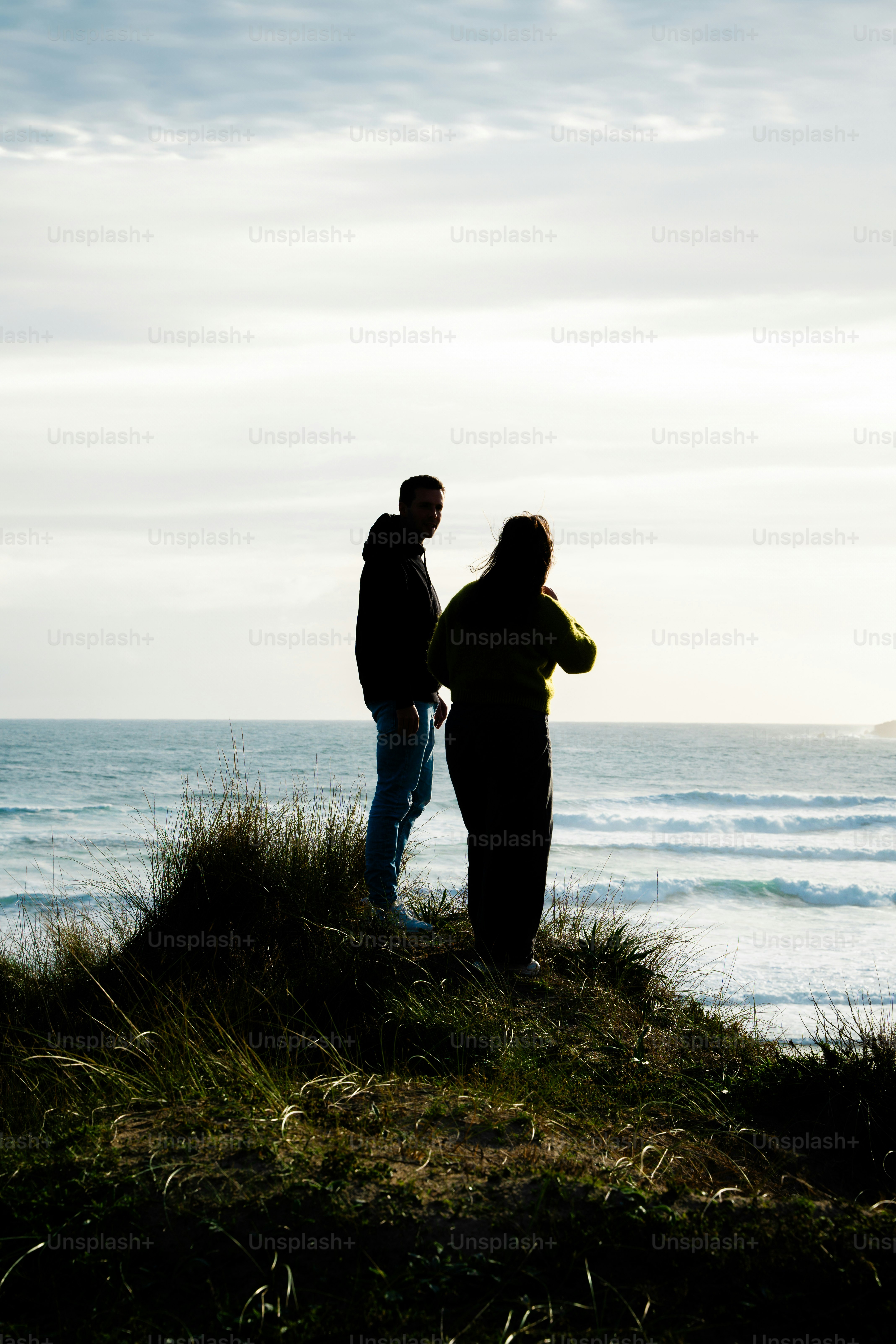 Two people talking by the water at dusk photo – People Image on Unsplash