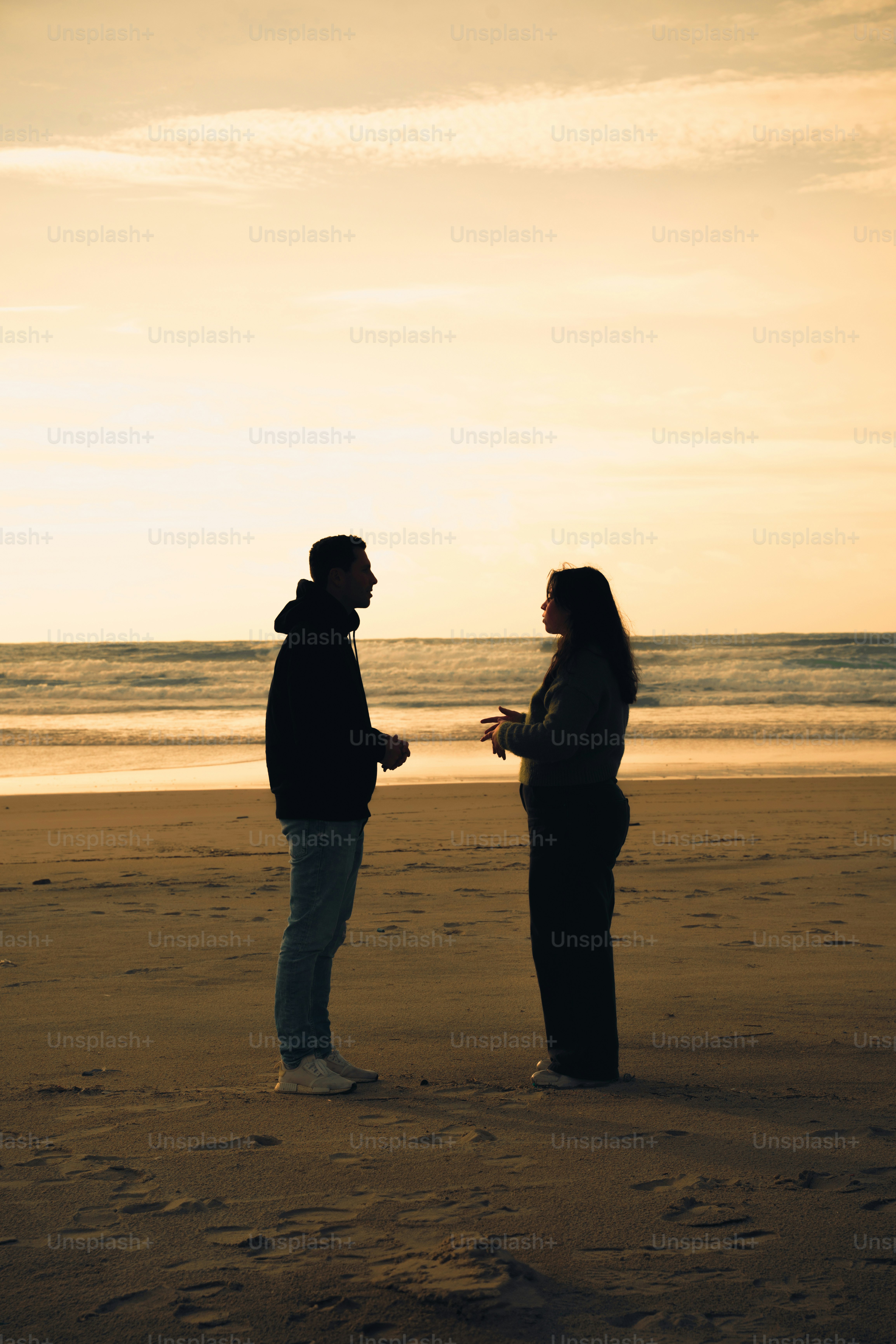 Pasangan berbicara di pantai saat matahari terbenam