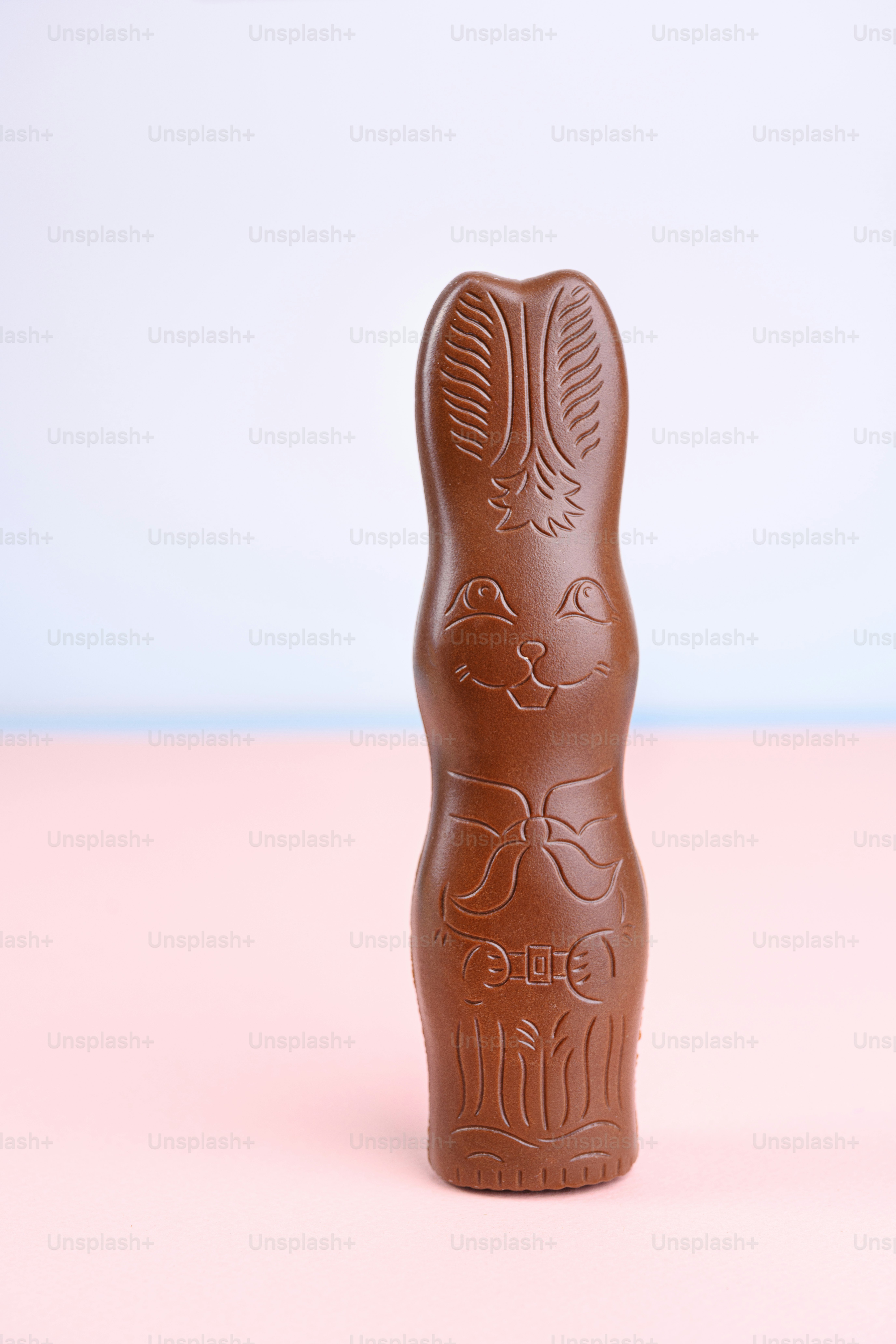 Kelinci cokelat susu padat dengan desain busur.