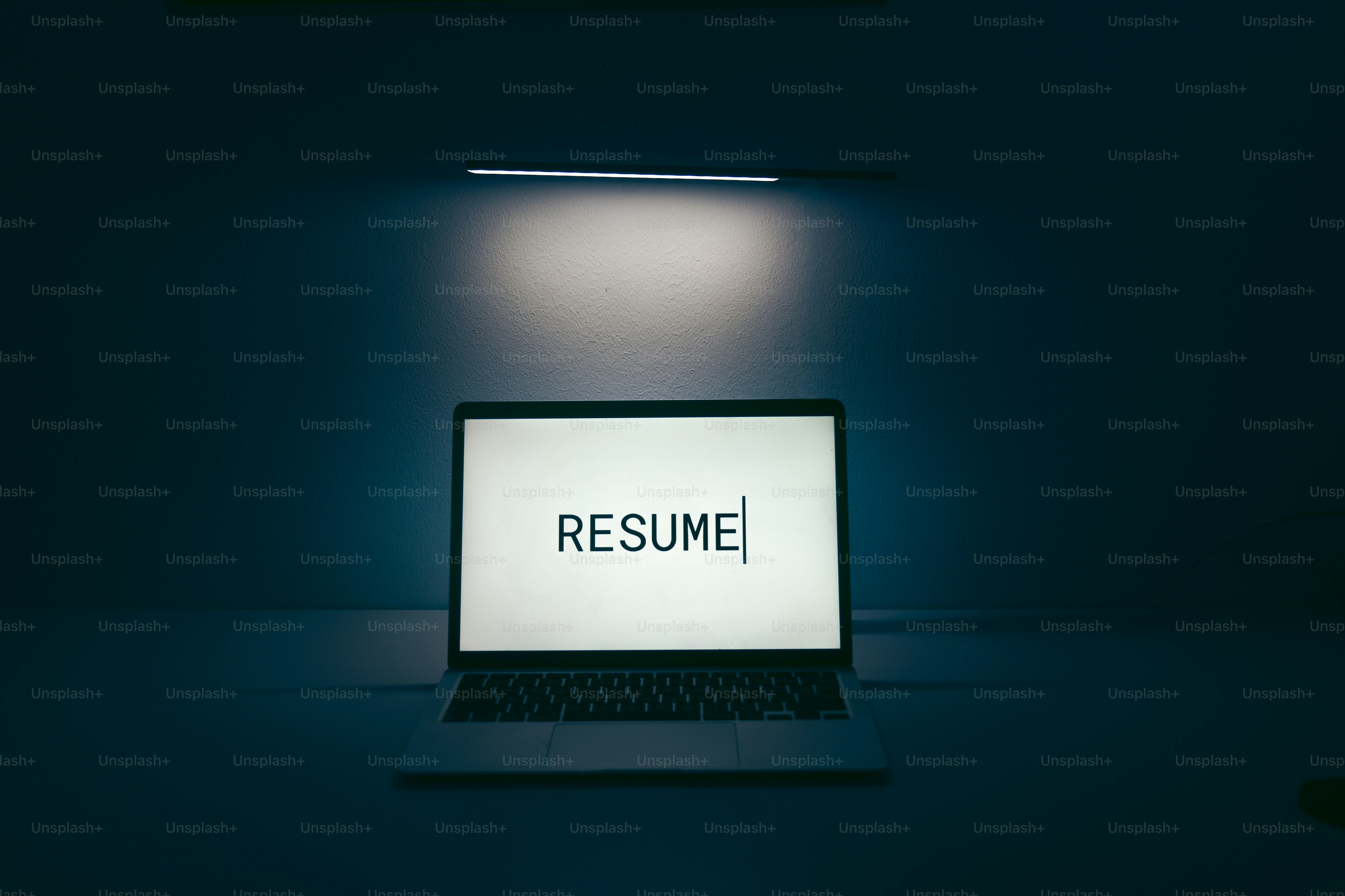 Laptop screen displays the word resume.