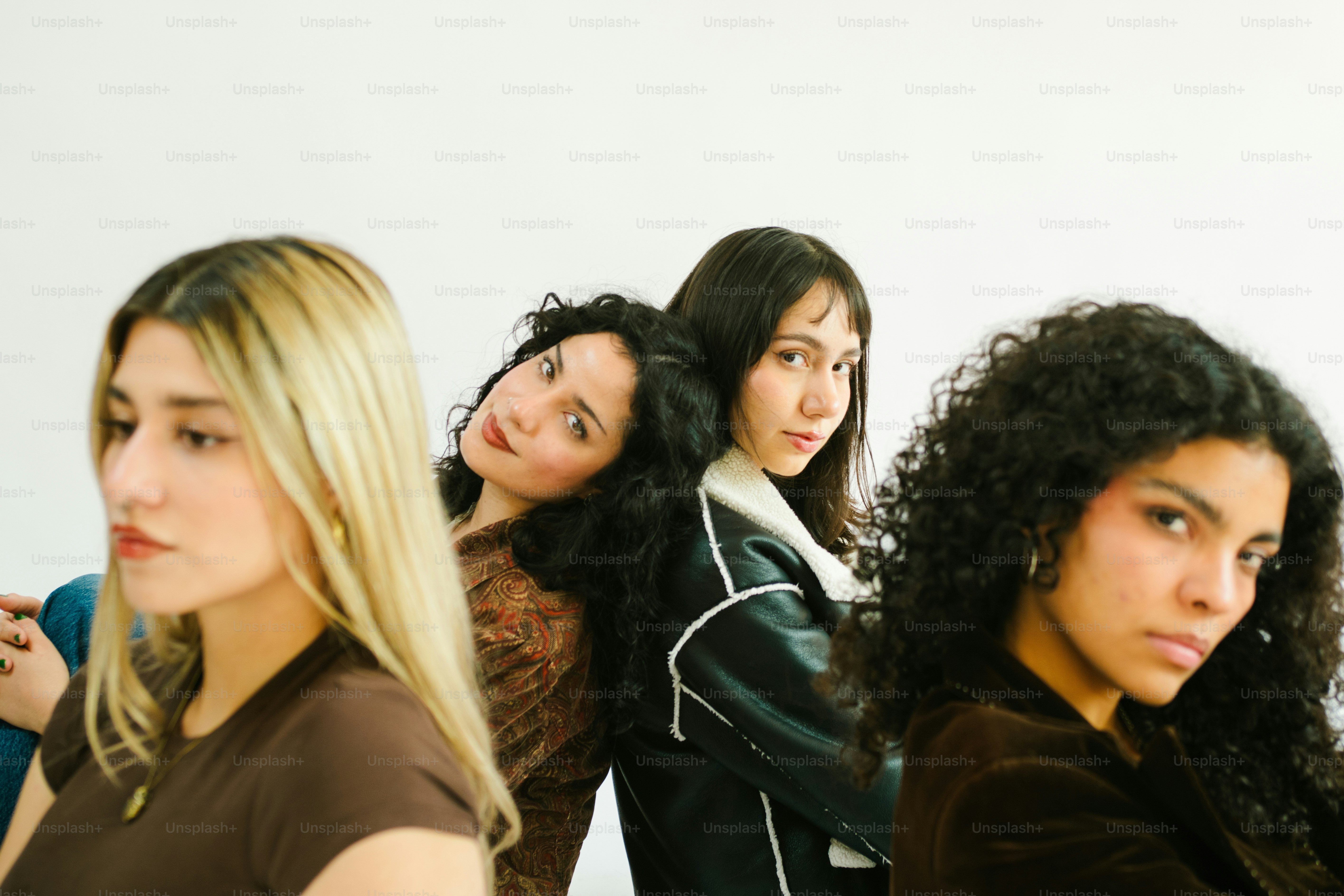 Quattro giovani donne che posano su uno sfondo bianco