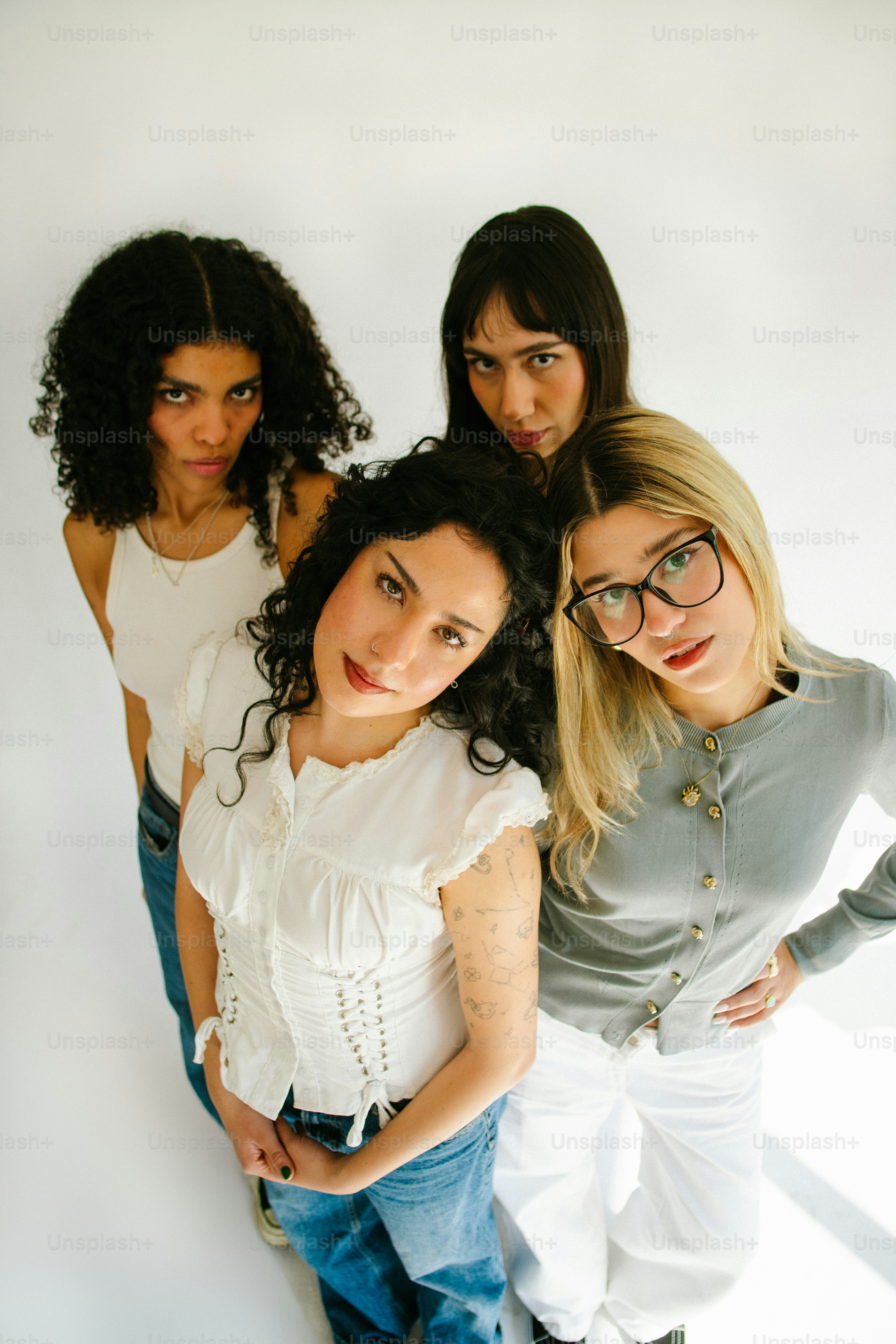 Quattro giovani donne che posano su uno sfondo bianco