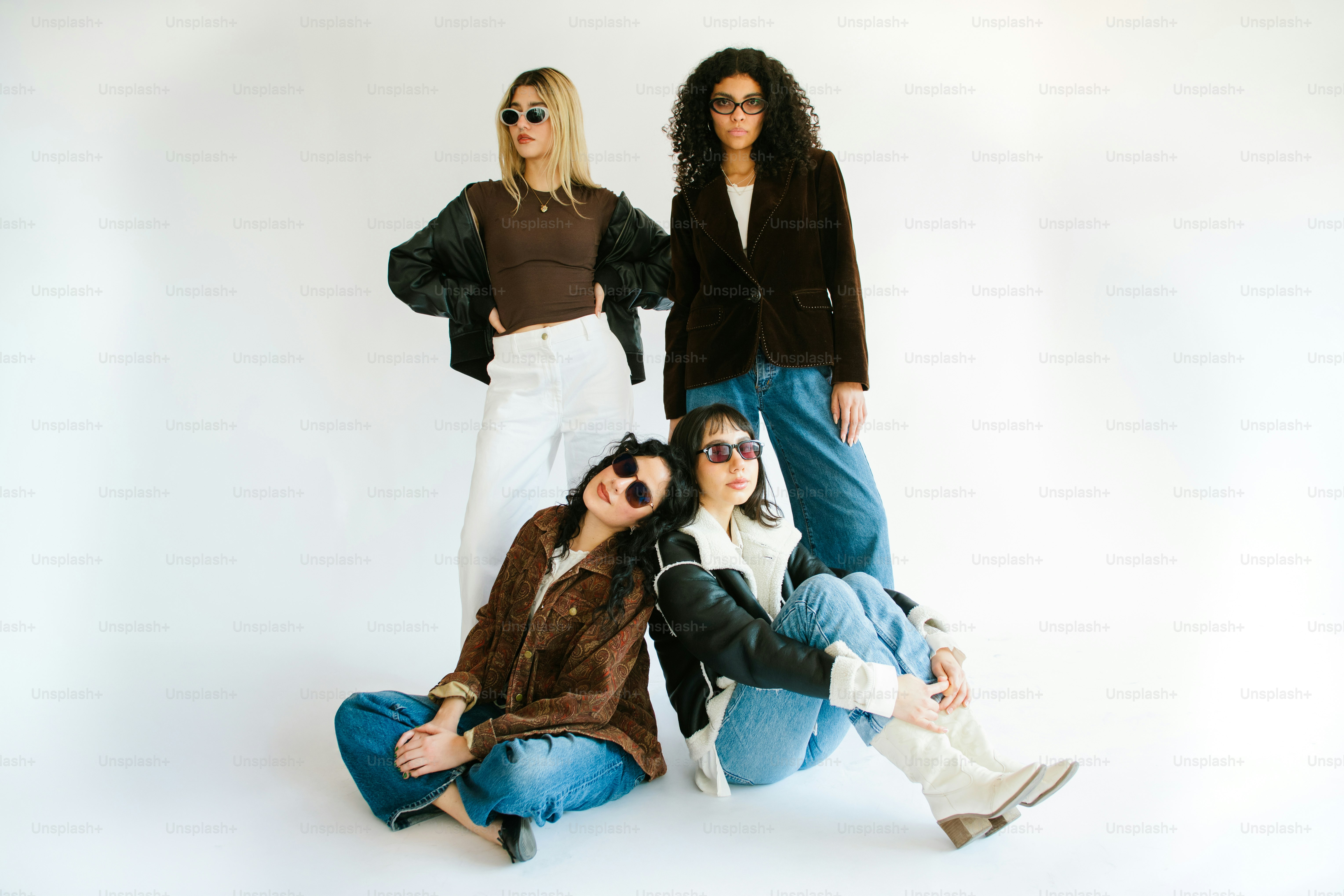 Quattro donne alla moda che posano in uno studio.