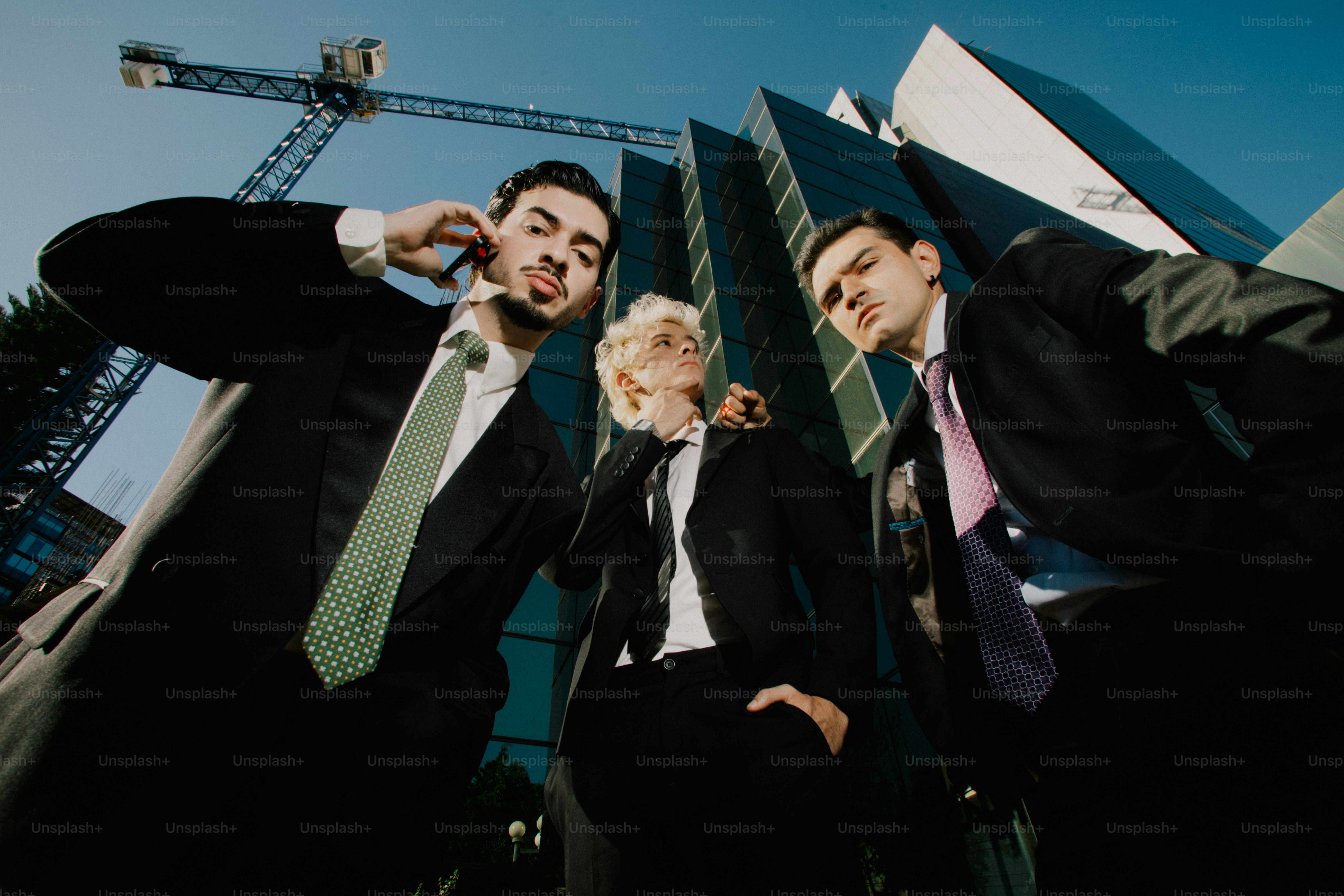 Three businessmen looking down at the camera.