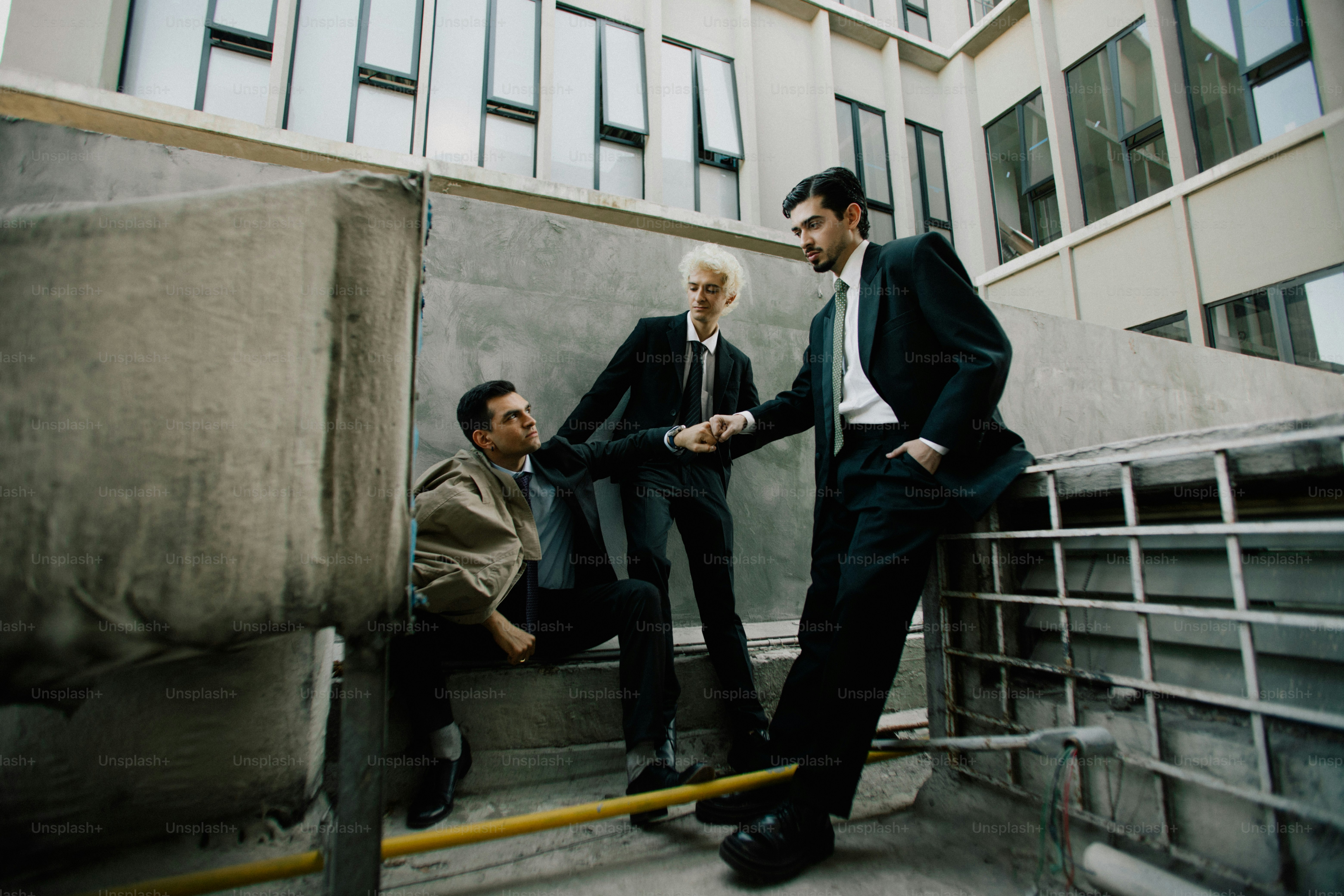 Three businessmen in suits standing outside office building photo ...