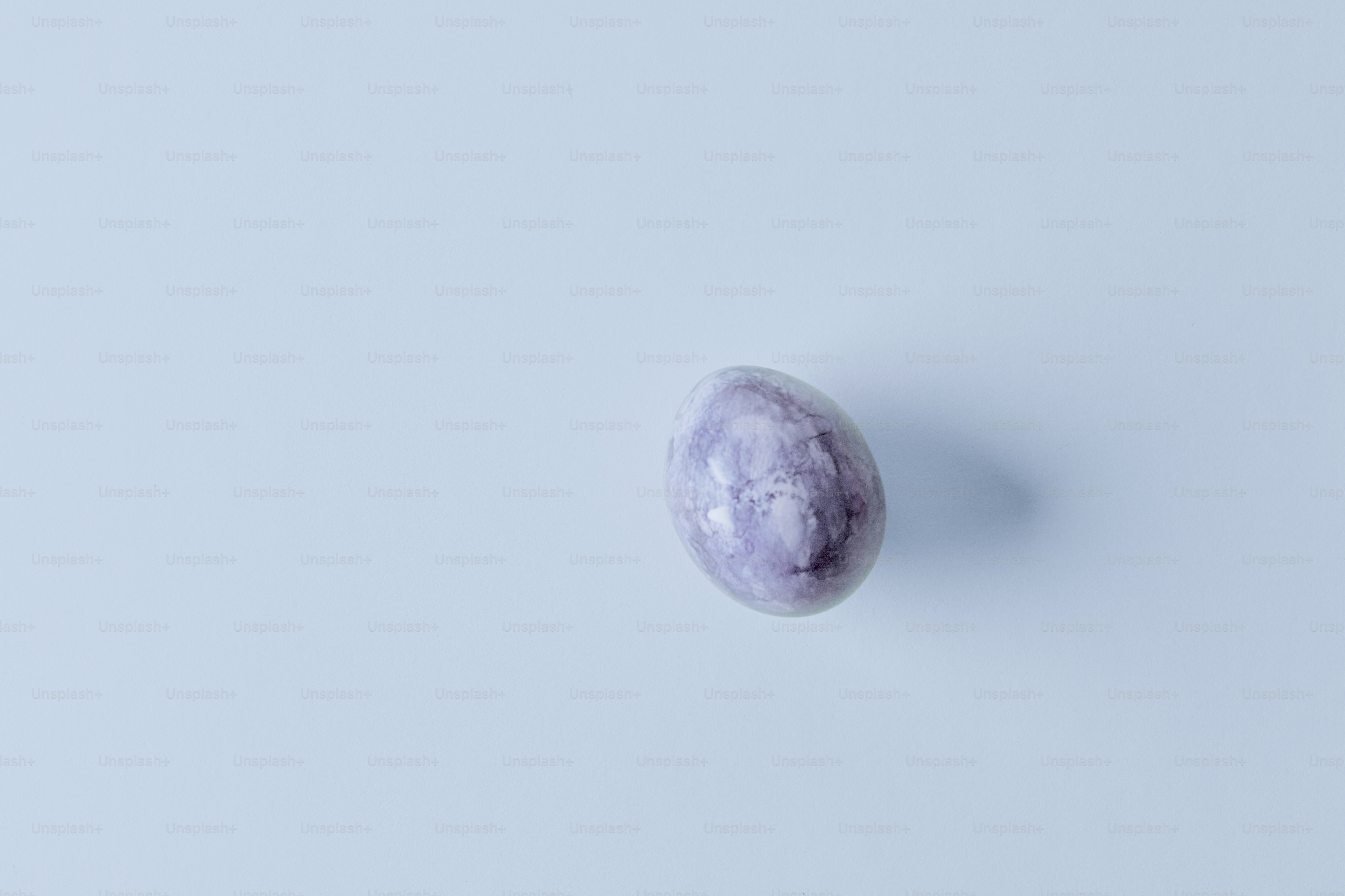 A single purple speckled egg on a light blue background. photo – Spring ...