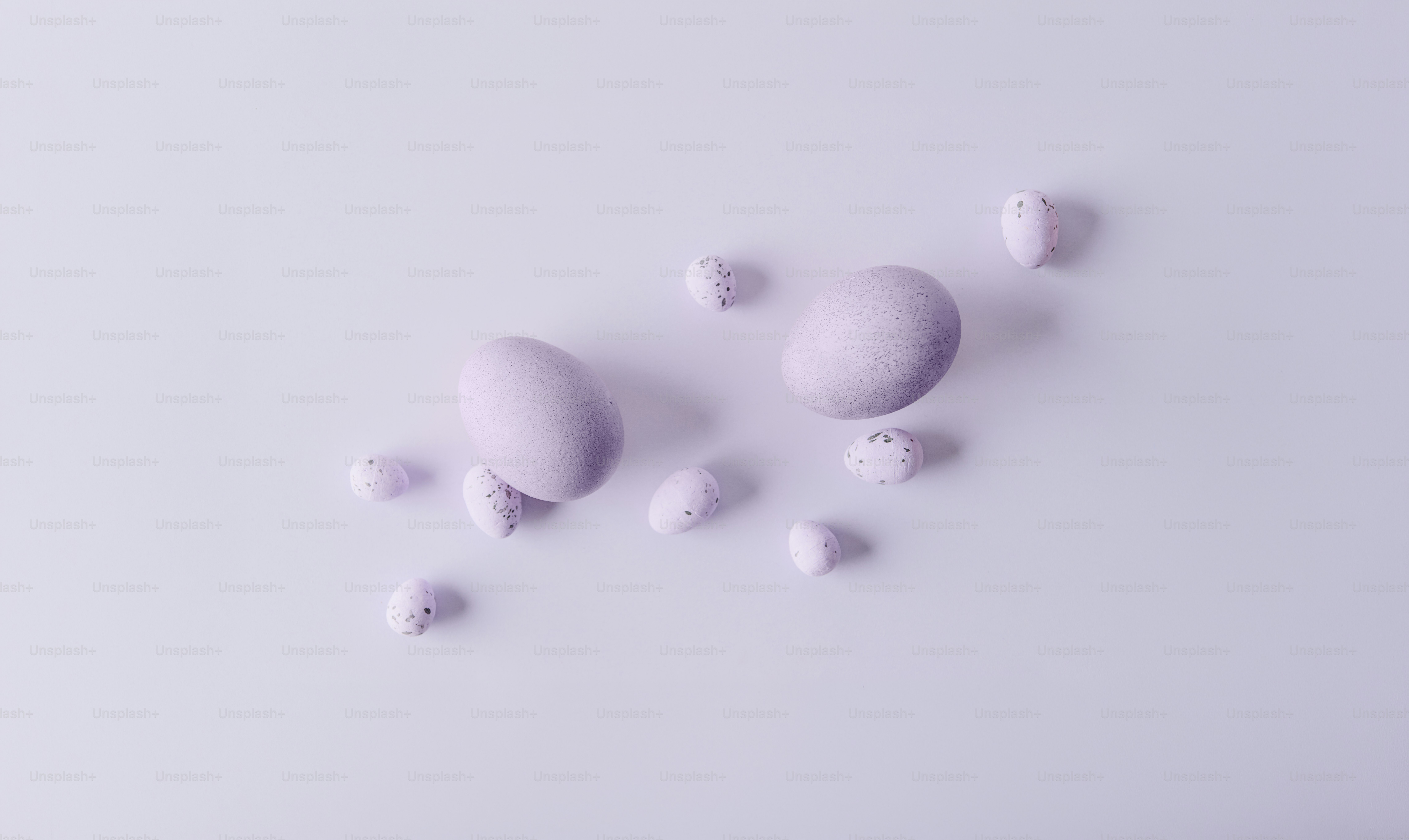 Two lavender eggs surrounded by small lavender shapes.
