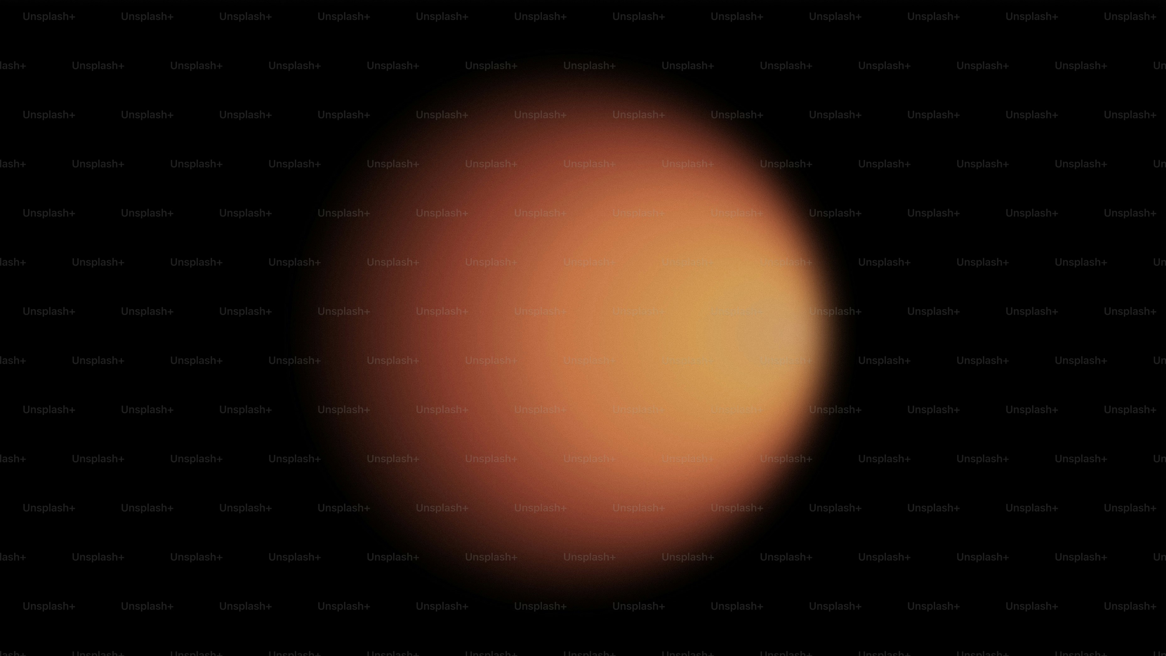 검은 배경 위에 흐릿한 주황색 구체가 있었다.