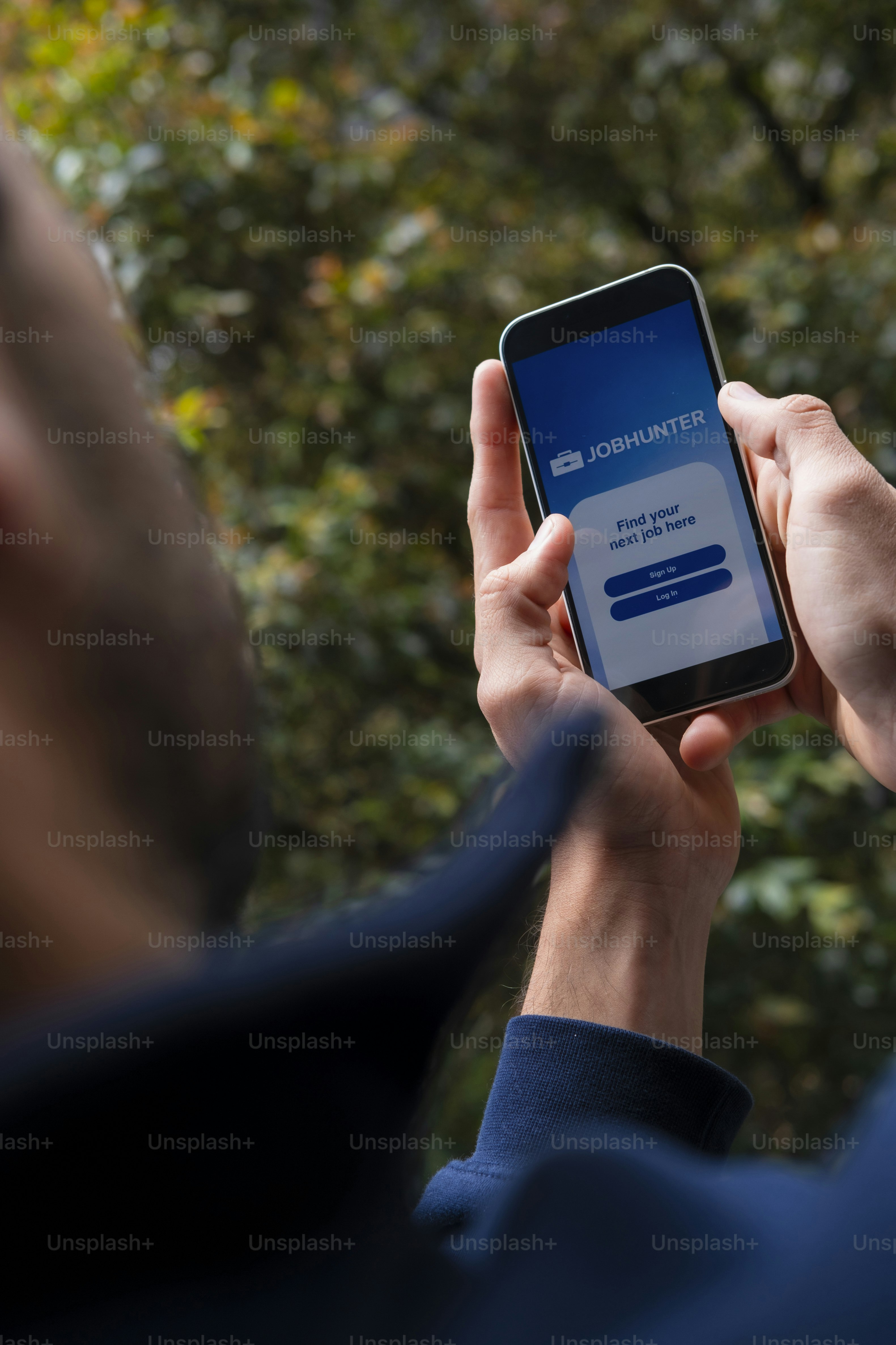 Mann nutzt eine Jobsuch-App auf dem Smartphone draußen