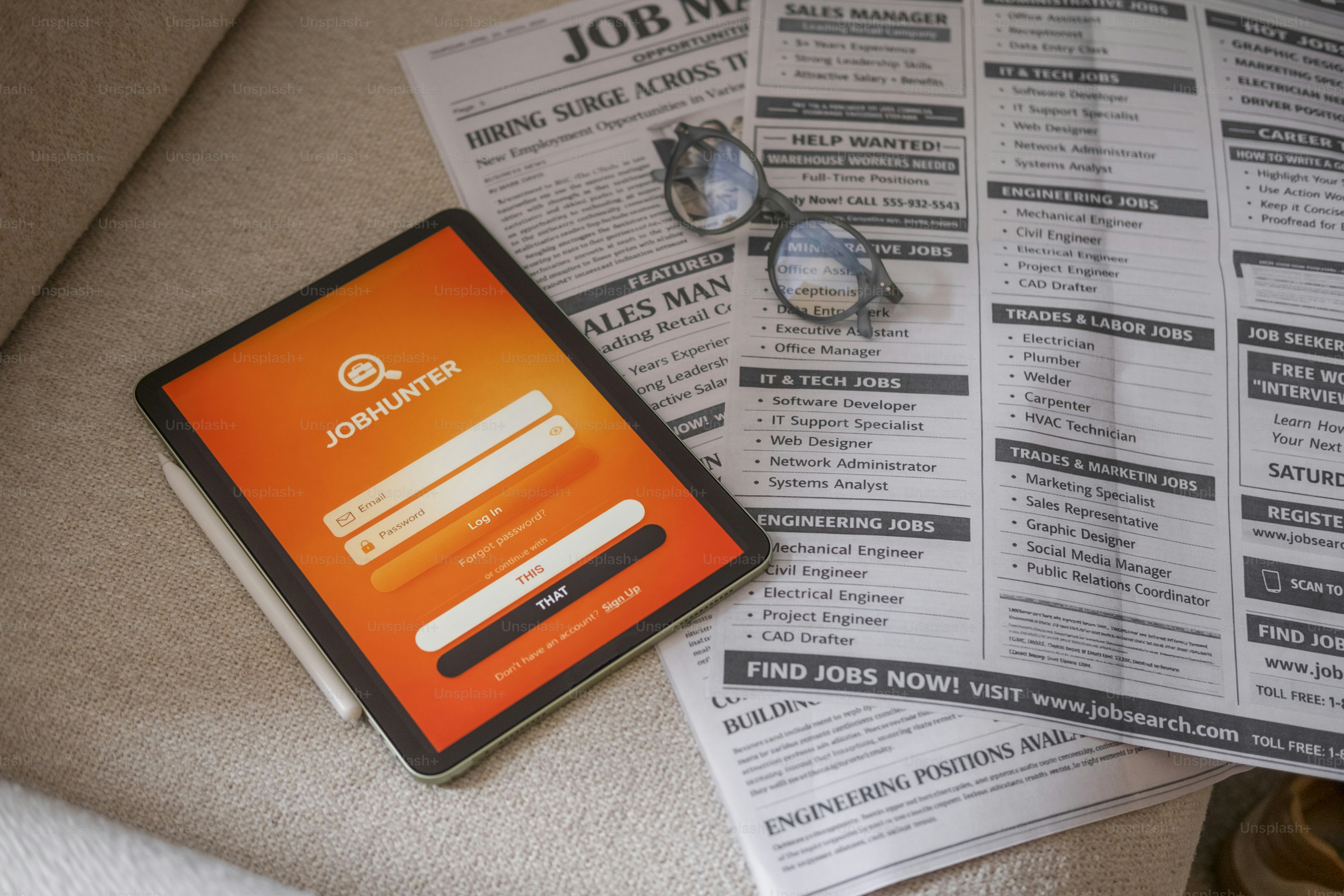 Tablet and newspaper with job listings