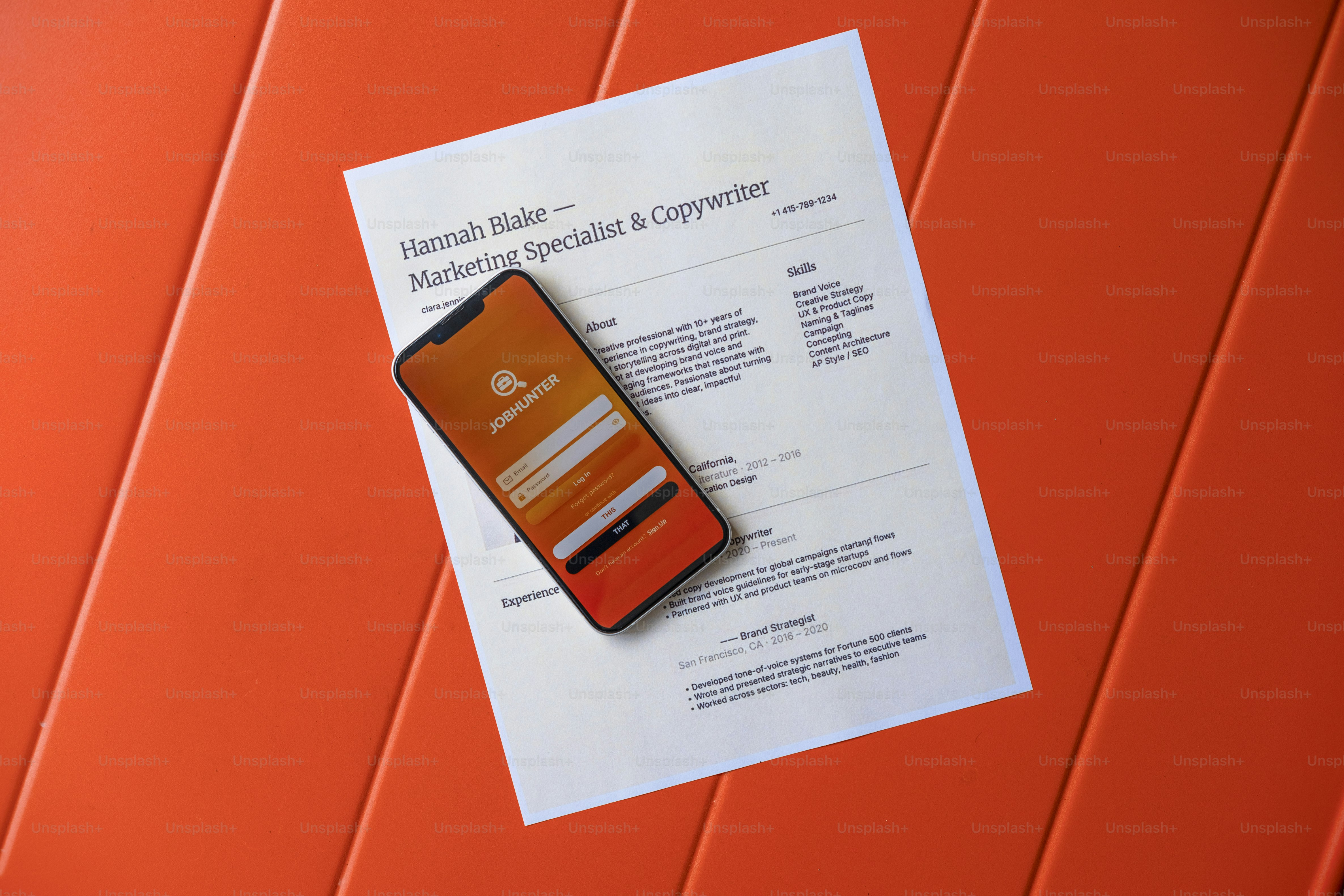 Lanjutkan dan smartphone dengan latar belakang oranye.