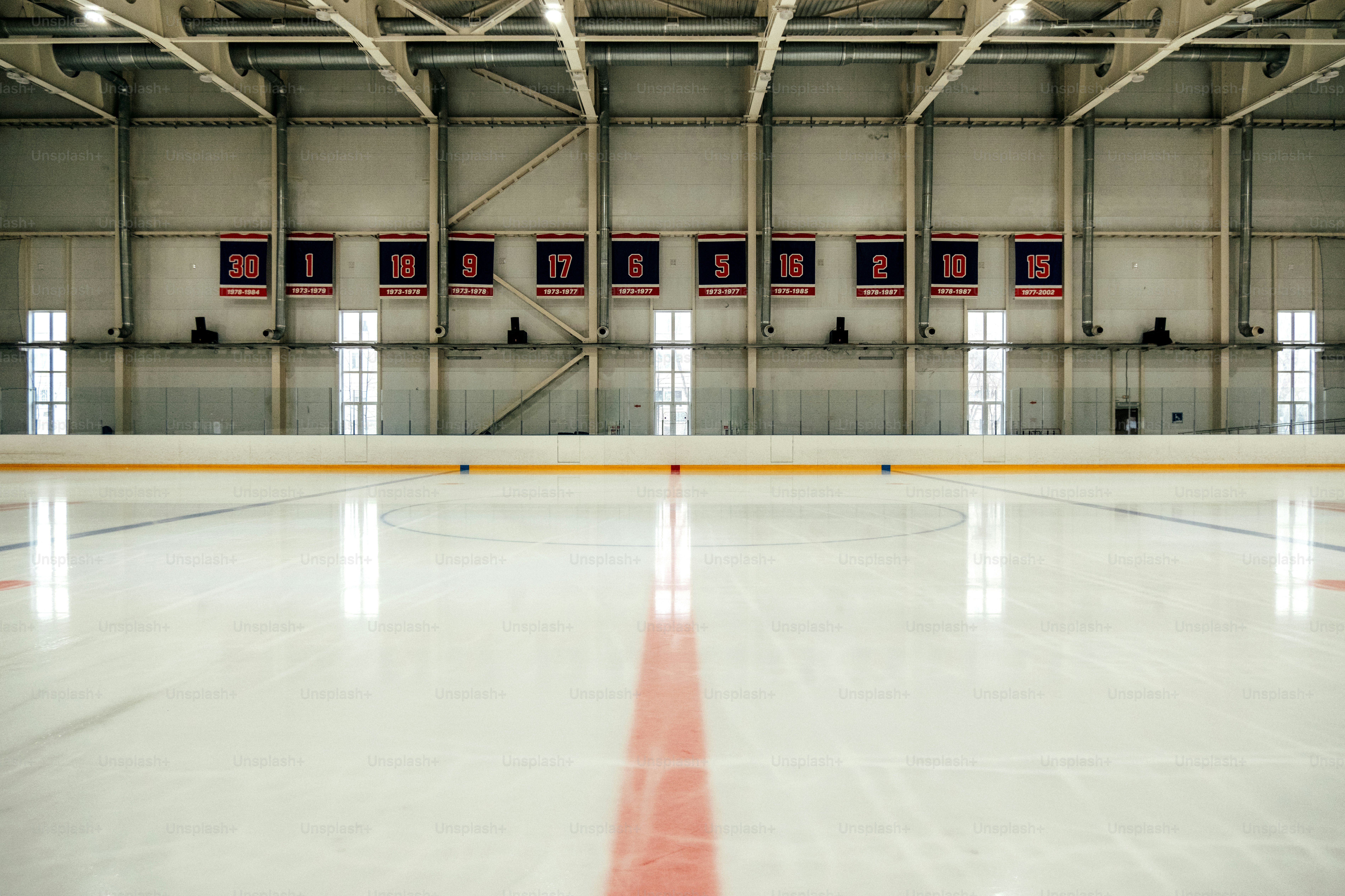 An empty ice hockey rink with banners hanging overhead