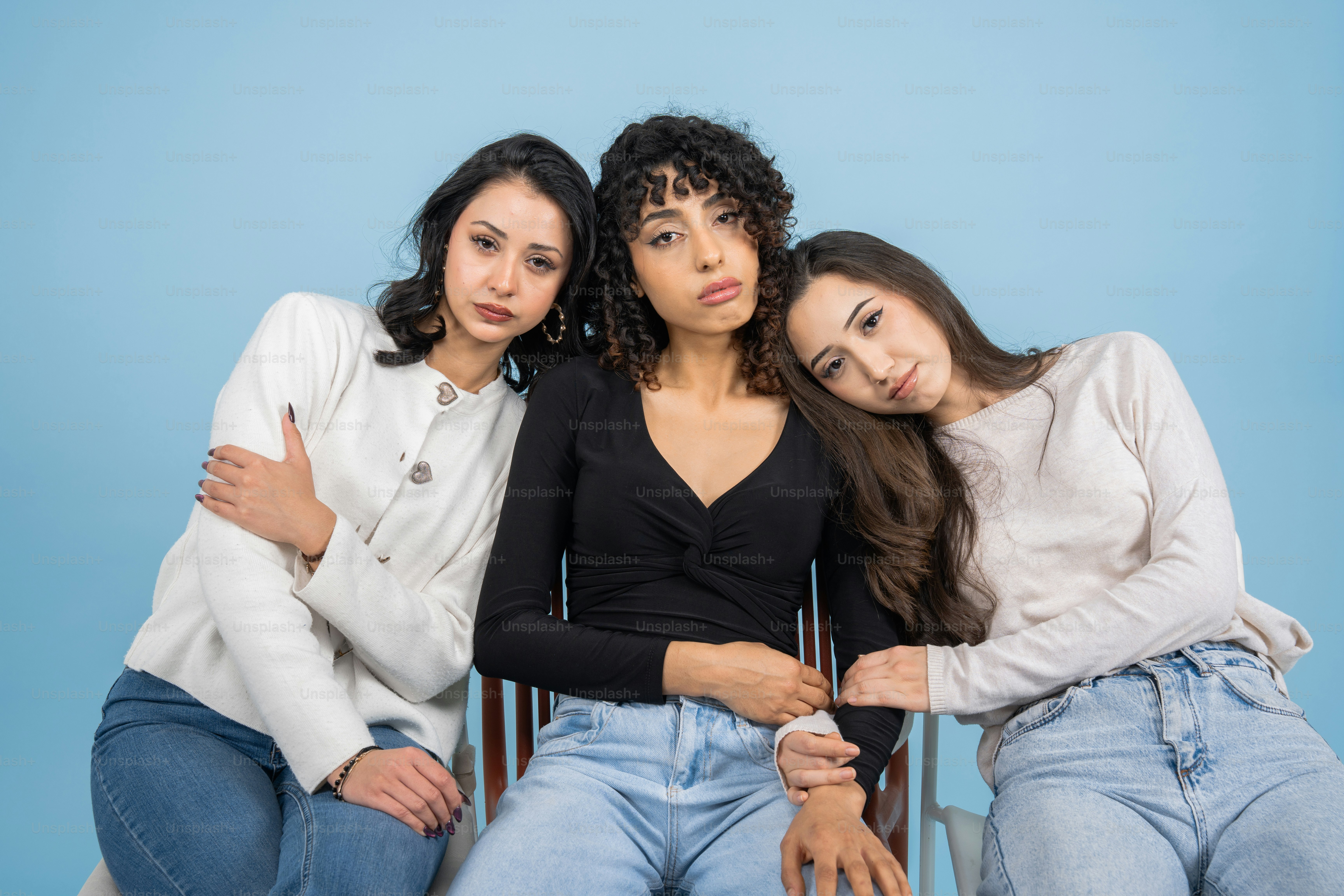Three young women posing against a blue background photo – Portrait ...