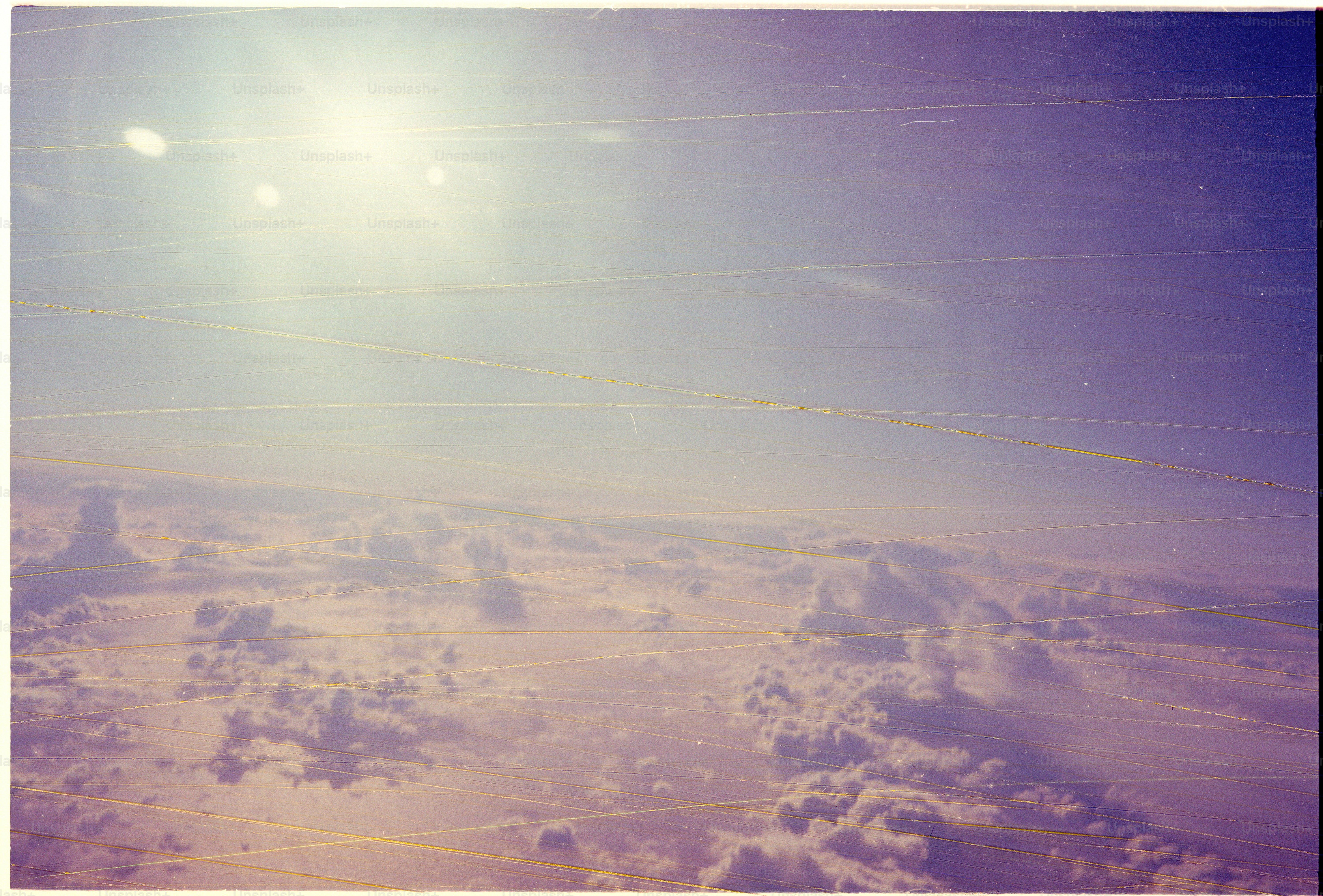 Sunlight shines through clouds from airplane window.