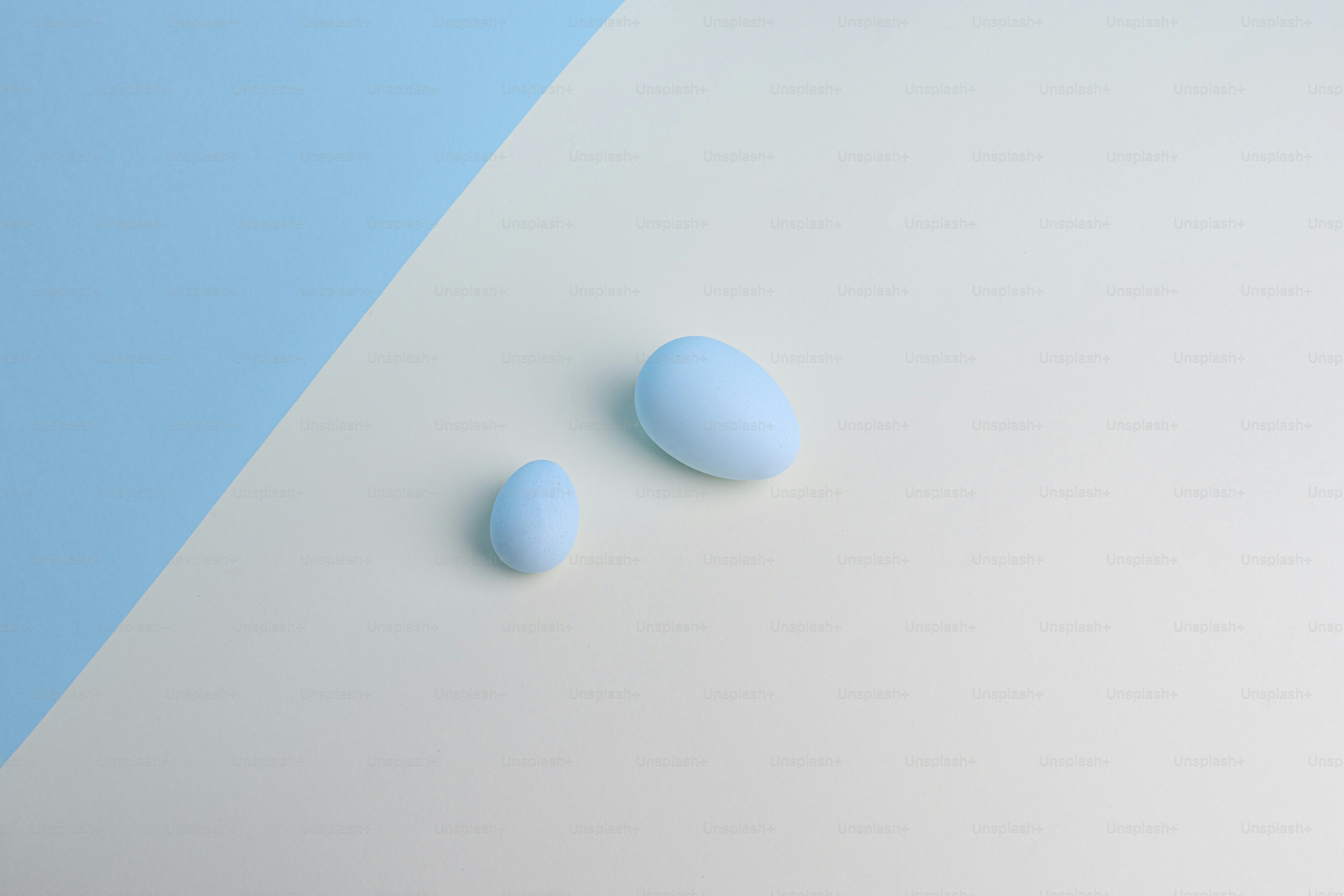 Zwei pastellblaue Eier auf weißem und blauem Hintergrund